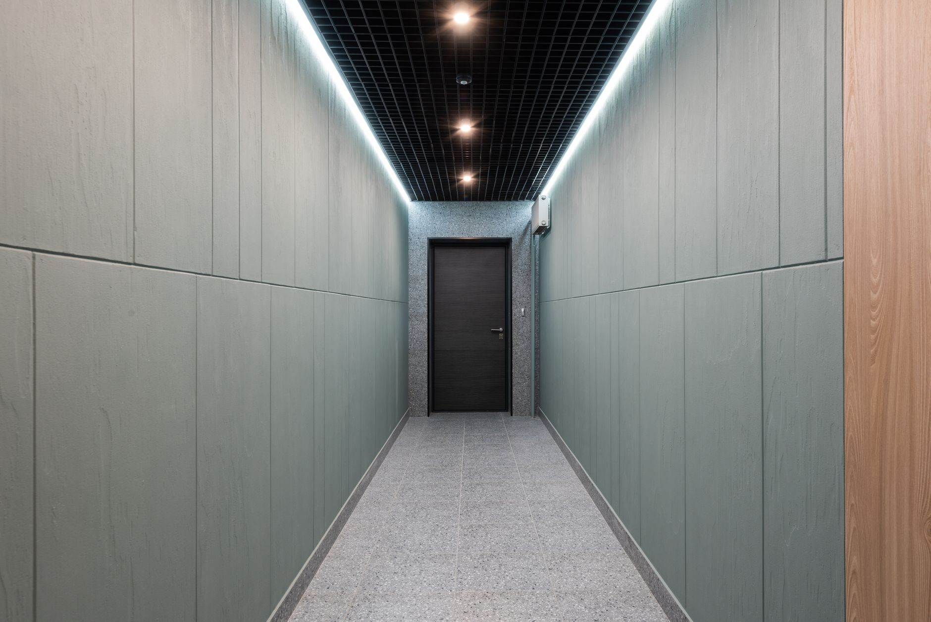 A quiet, empty office corridor after hours, a typical patrol route for an AI-powered robotic security guard.