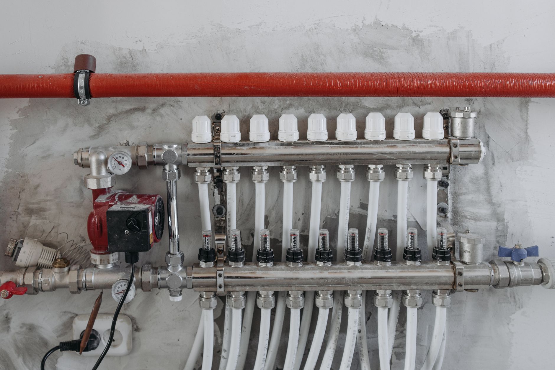 Building systems room with pipes, valves, and controls, reflecting the operational backbone behind a modern event venue.