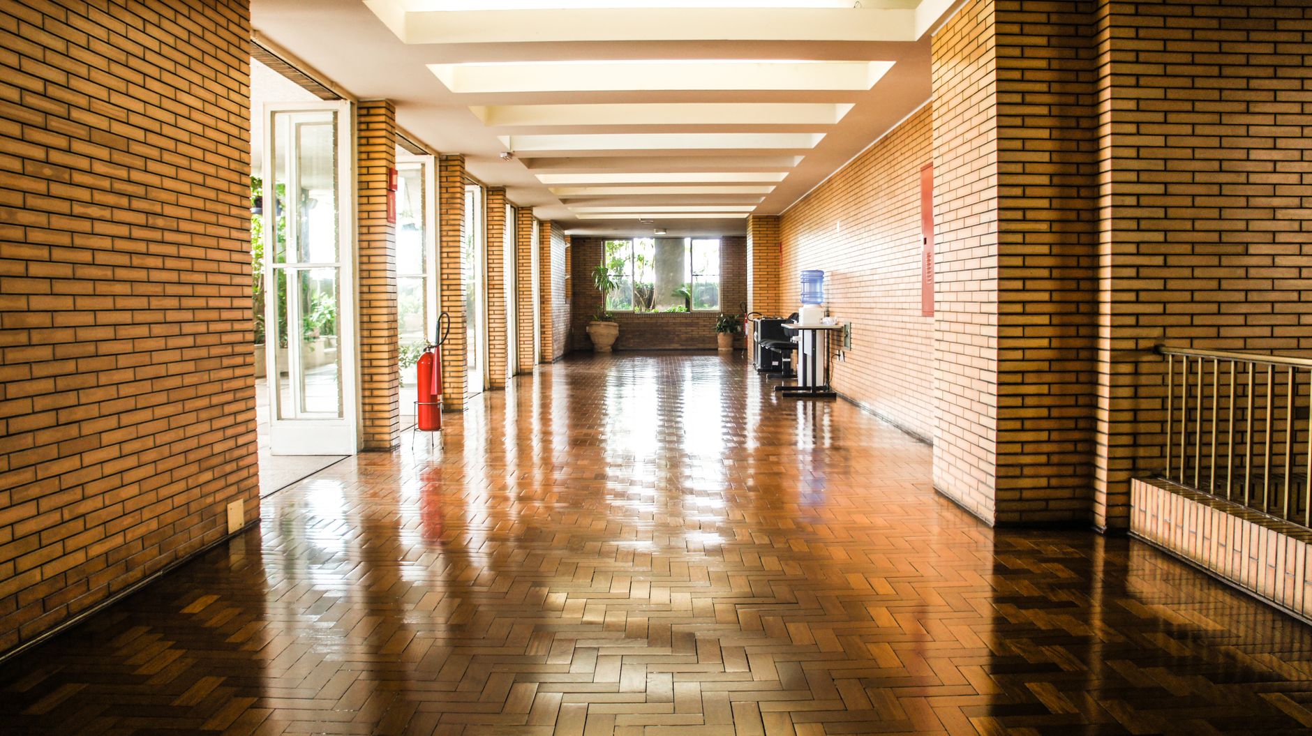Nighttime floor cleaning in a long public corridor, illustrating the repetitive turnaround work arenas need finished between events.