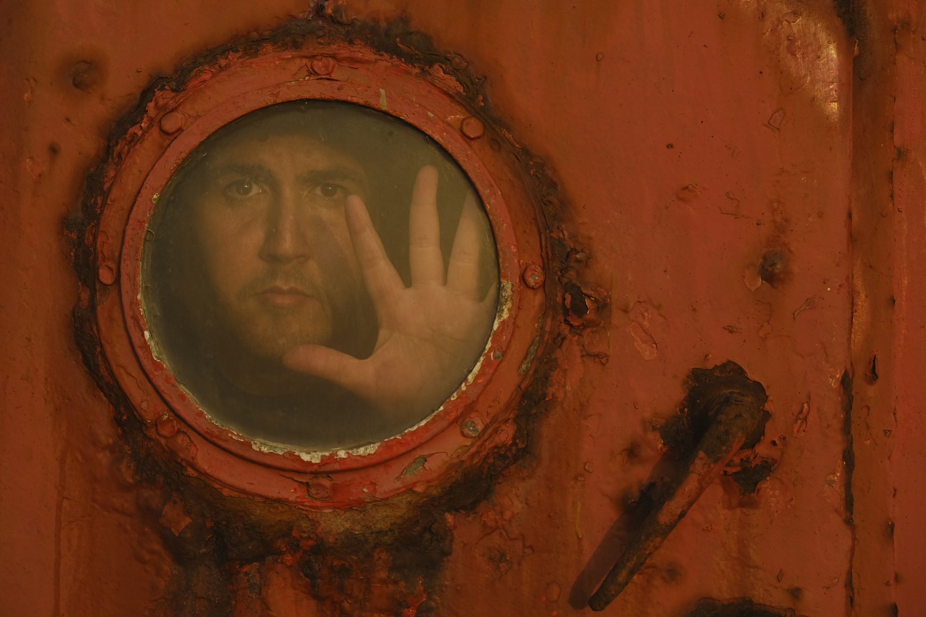 A safety-equipped worker prepares to inspect a hazardous confined industrial space.