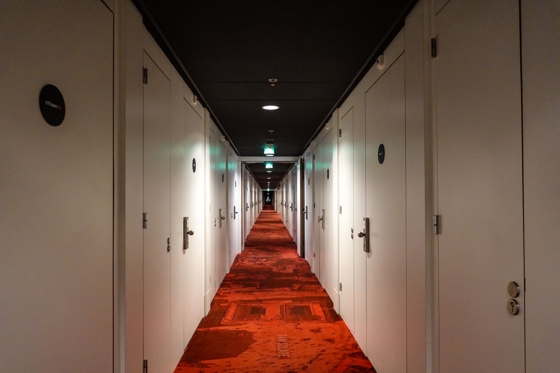 Long corridor with repeating doors, reinforcing the article's point about repeatable service standards across many similar sites.