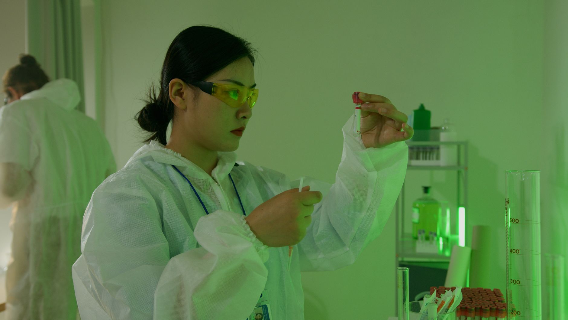 A laboratory professional inspects samples as part of the repeatability and quality discipline required in life sciences manufacturing.