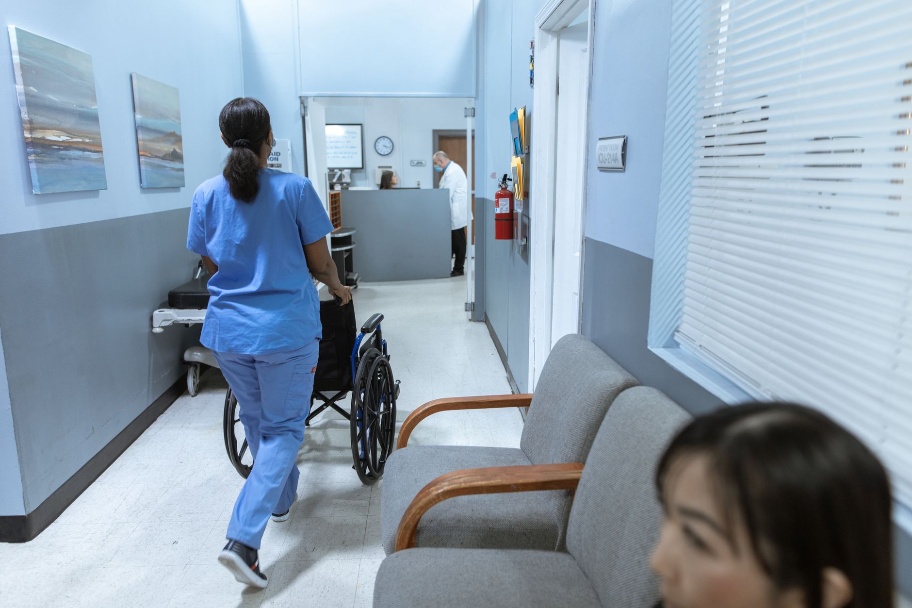 A clean clinic hallway with exam room doors and limited clearance, matching the outpatient sites that may now be viable for compact scrubbers.