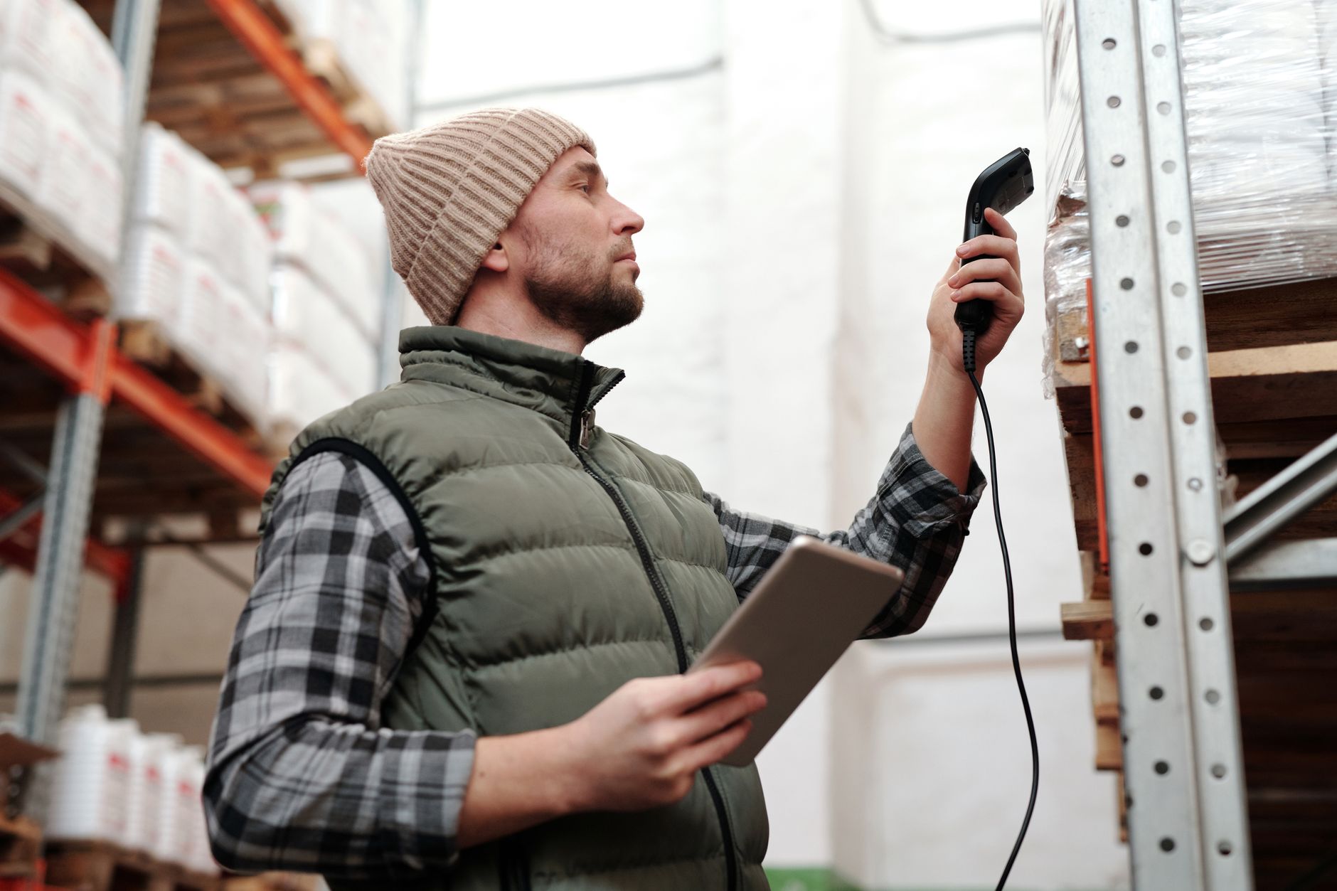 A warehouse worker scans packages, representing a higher-value task for which mobile robots can free up human staff.