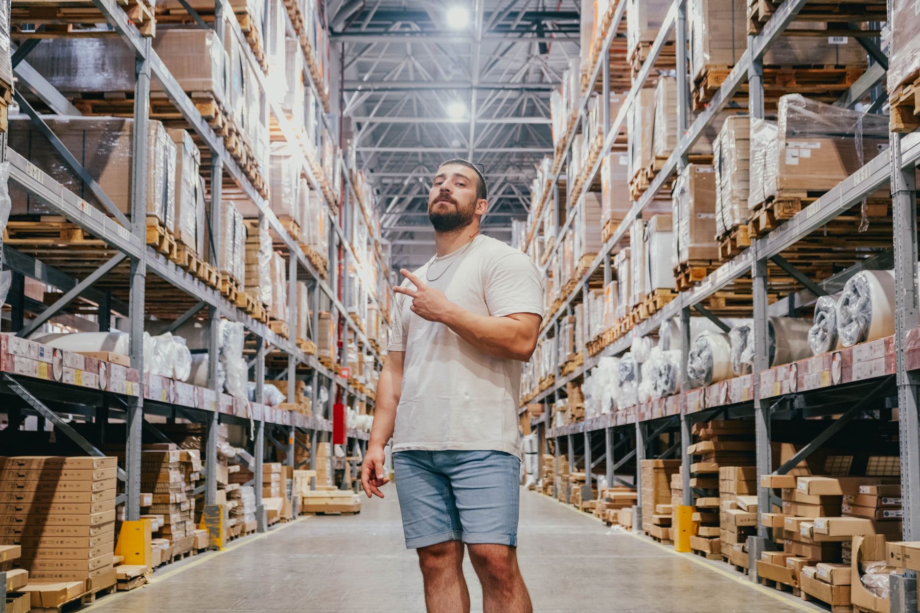 A wide, clean, and modern warehouse aisle with tall shelving, representing the logistics environments where mobile robots are deployed.