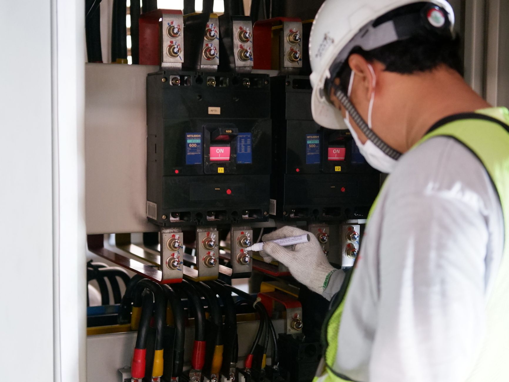 A technician carefully inspects a complex wiring panel, representing the focus on safety and proficiency that comes with a certified integrator.
