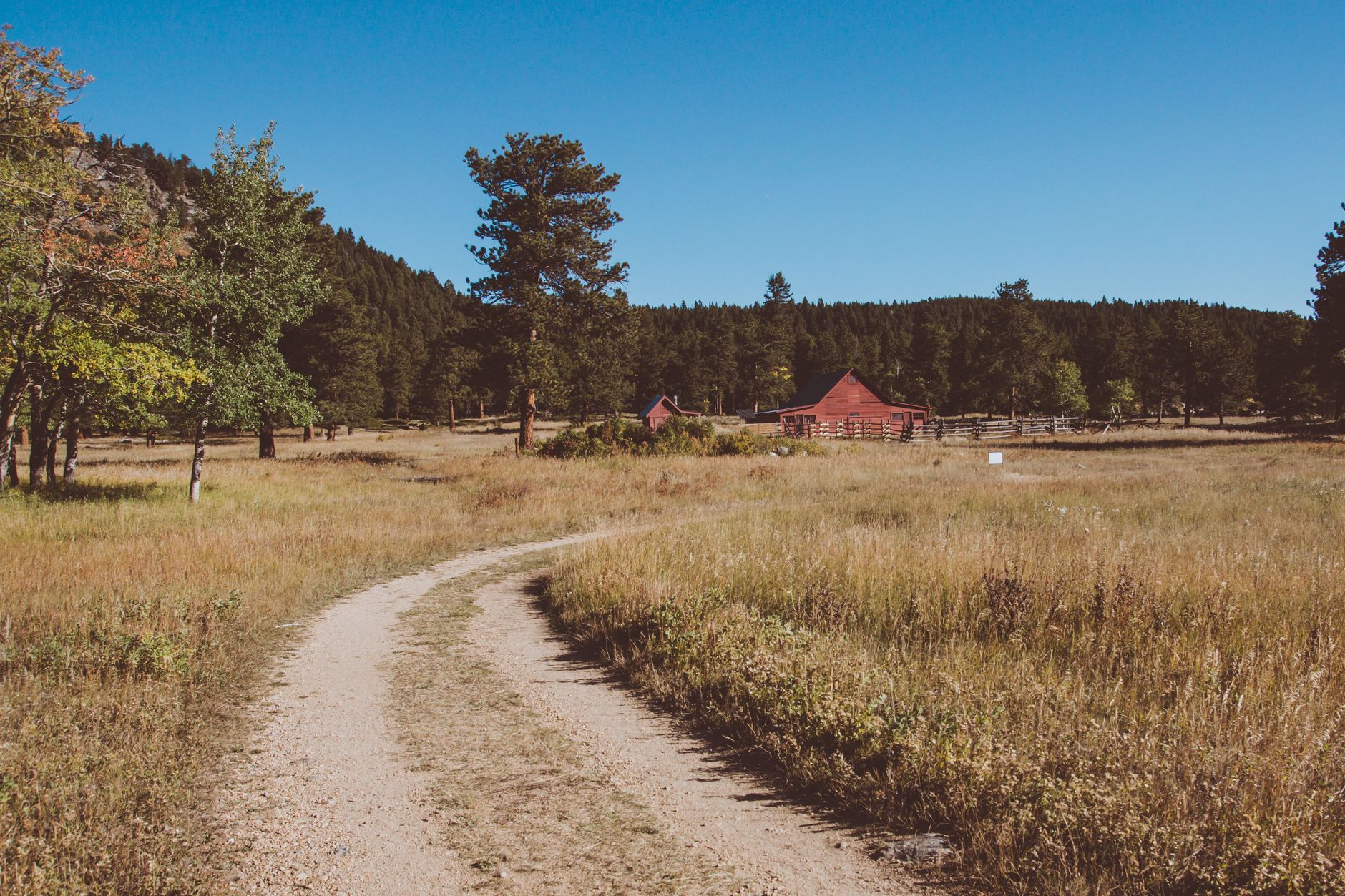 Rural ranch road with melting snow along the shoulder