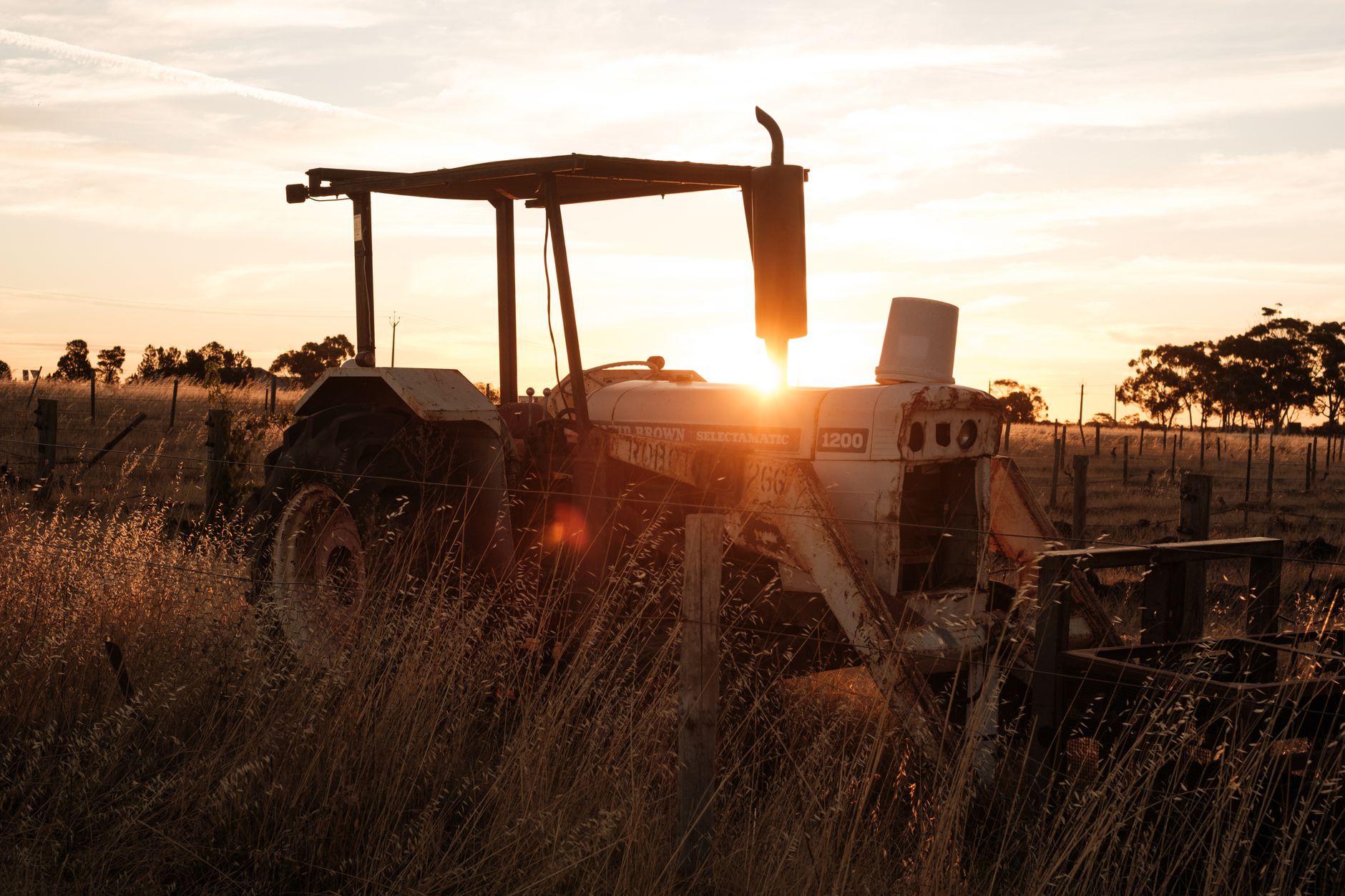 A crop tractor in the field where retrofit autonomy kits extend weekly operating hours.