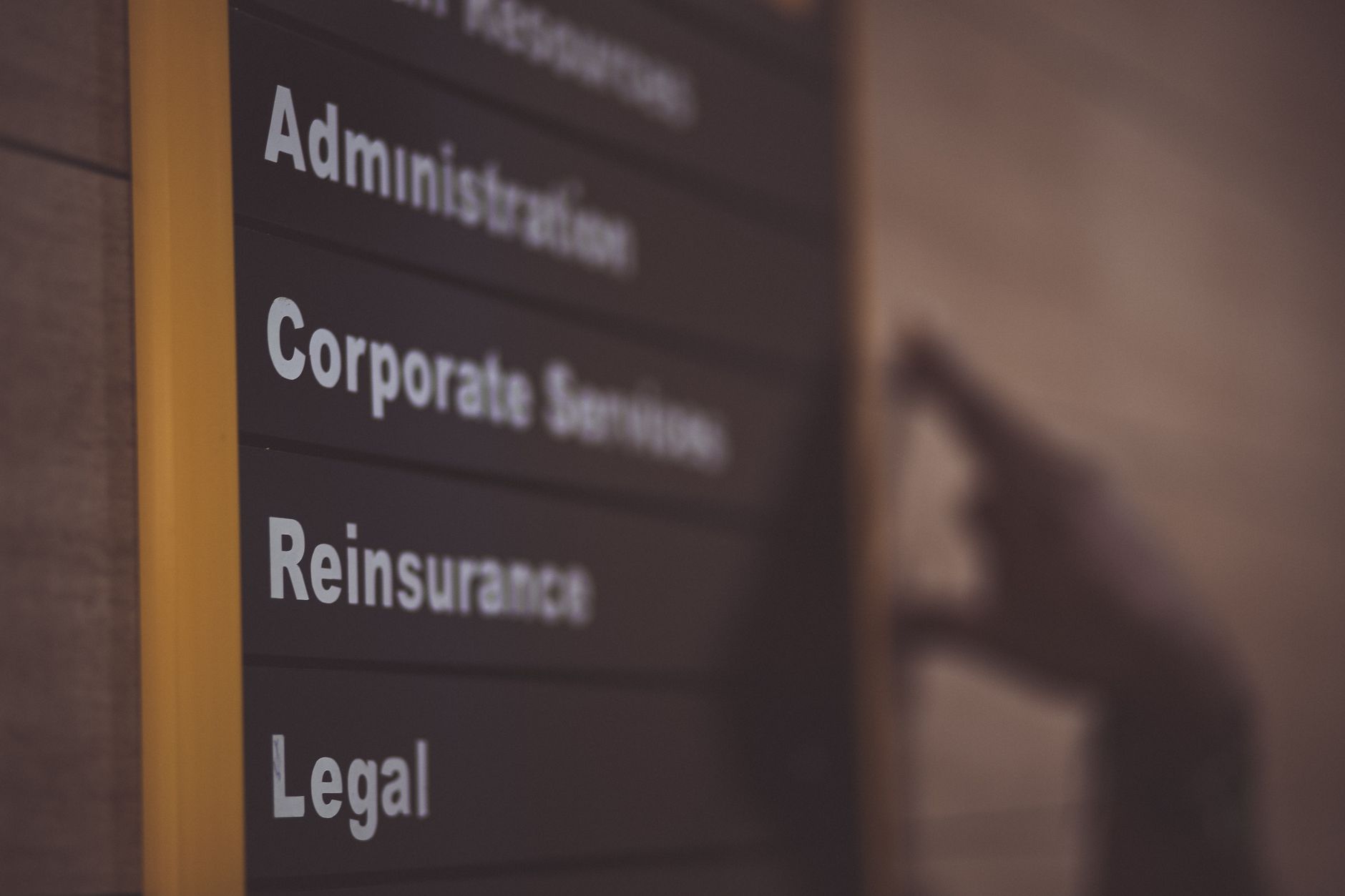 A visitor checking directory signage in a modern office building lobby.