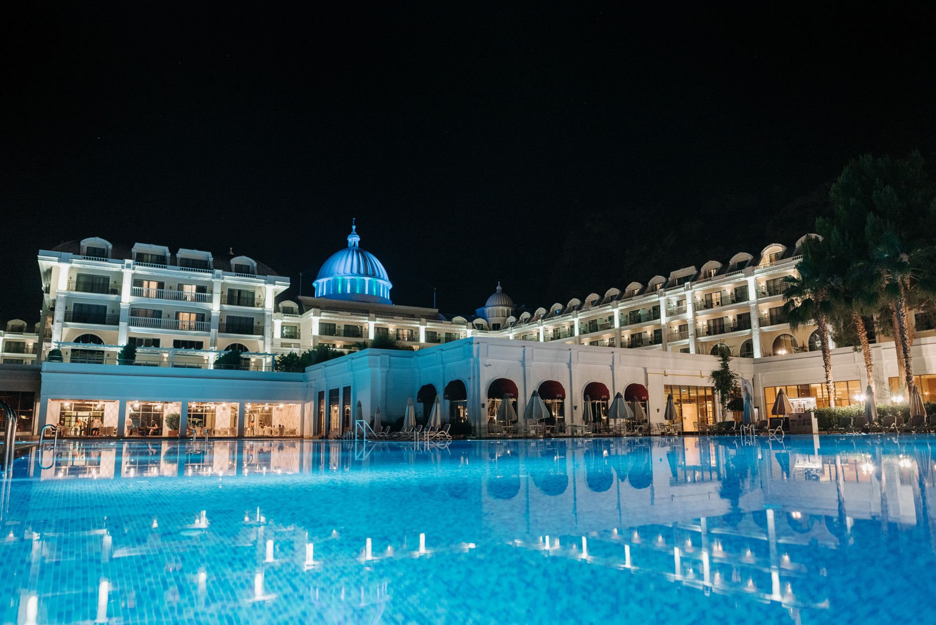 An illuminated hotel swimming pool after closing hours, reflecting the late-night maintenance setting in the case study.