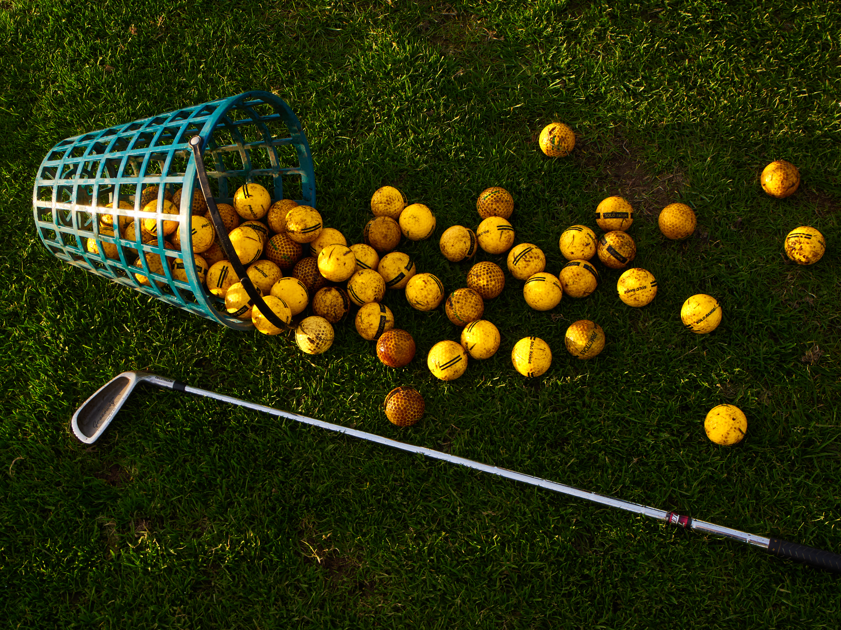 A basket filled with driving-range golf balls represents the high-volume collection and return workflow.