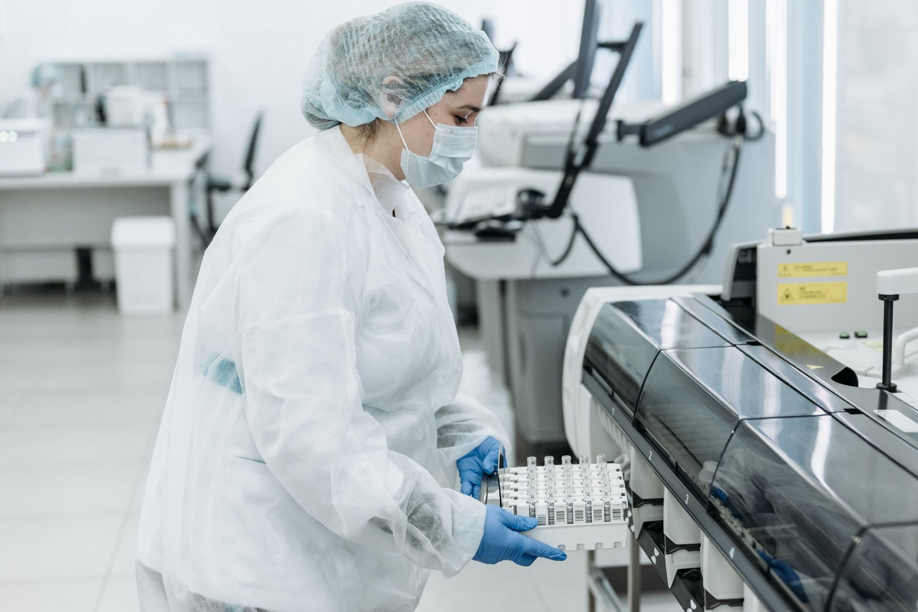 A medical laboratory professional handling blood samples at a clinical testing bench.