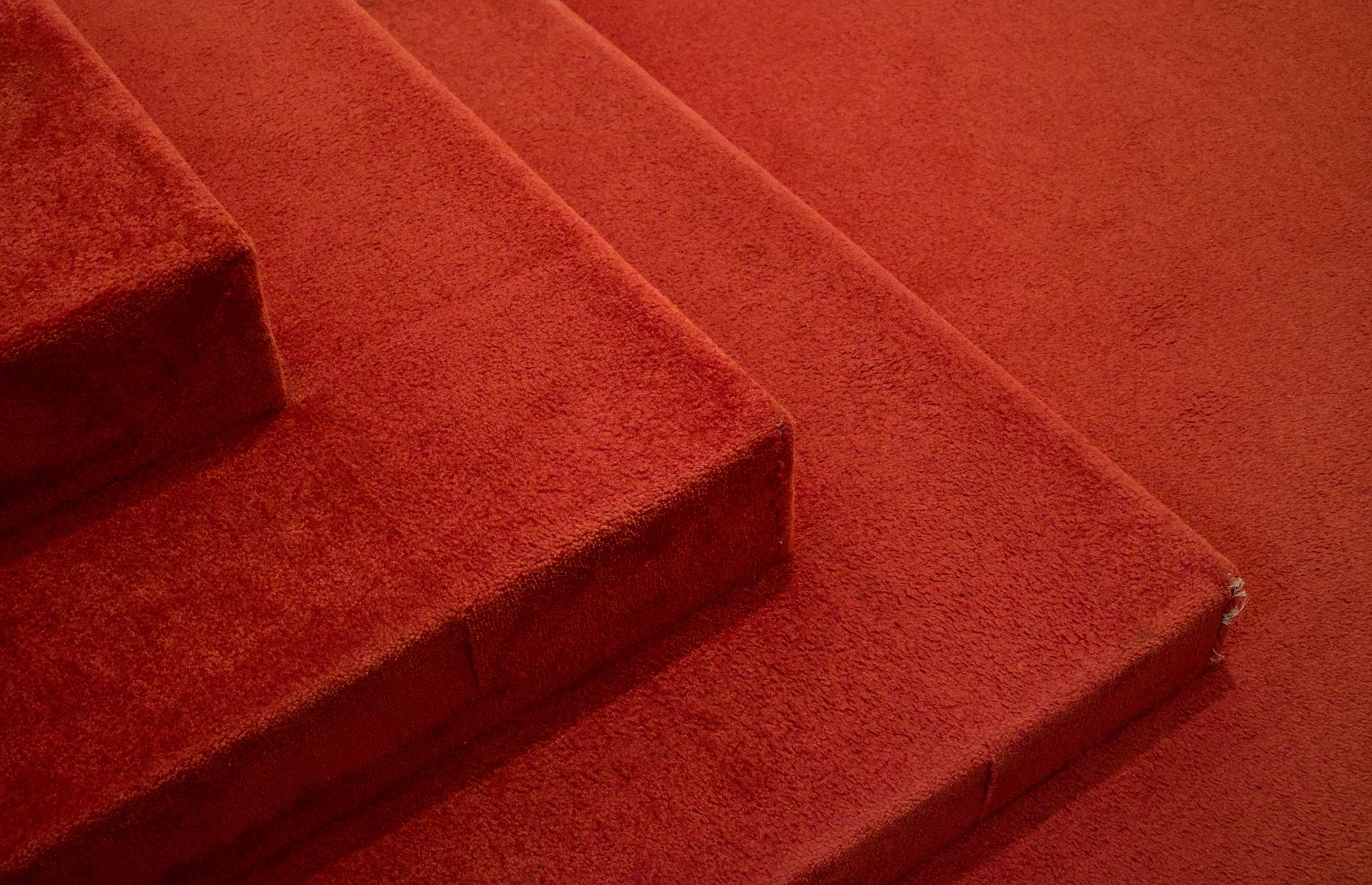 Close view of corridor carpet pile where regular vacuuming affects dust and presentation.