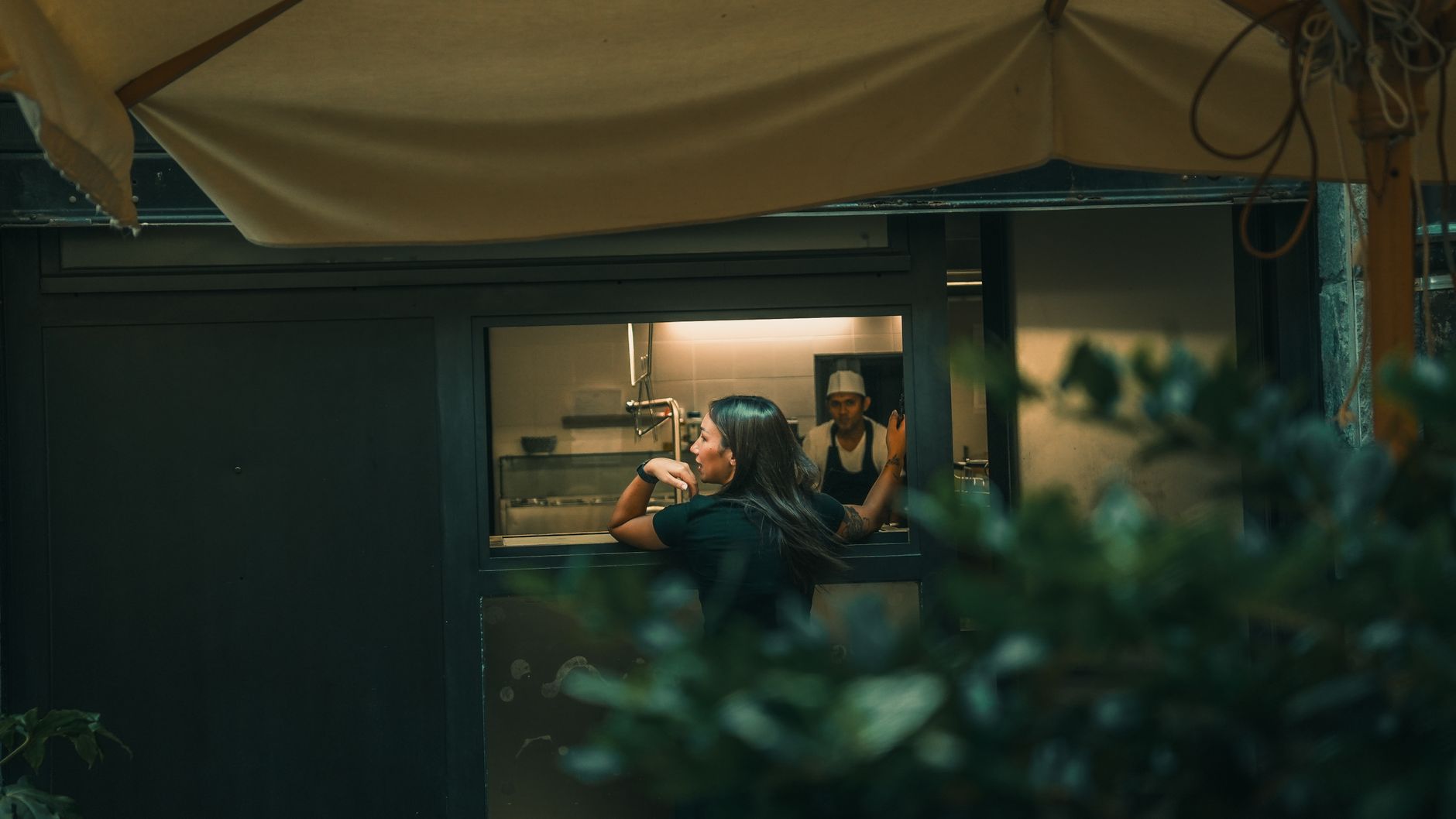 Dishes staged at a restaurant kitchen pass before servers or runners carry them to tables.