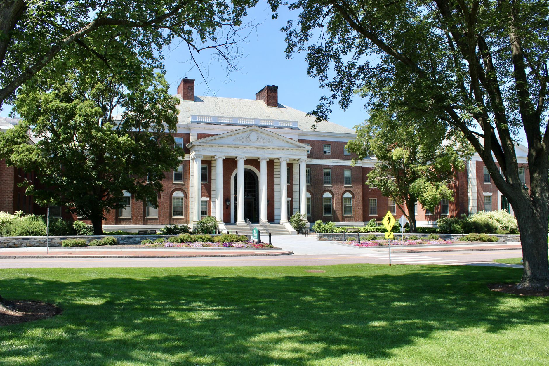 A broad front lawn on a school campus where grounds crews maintain open turf.