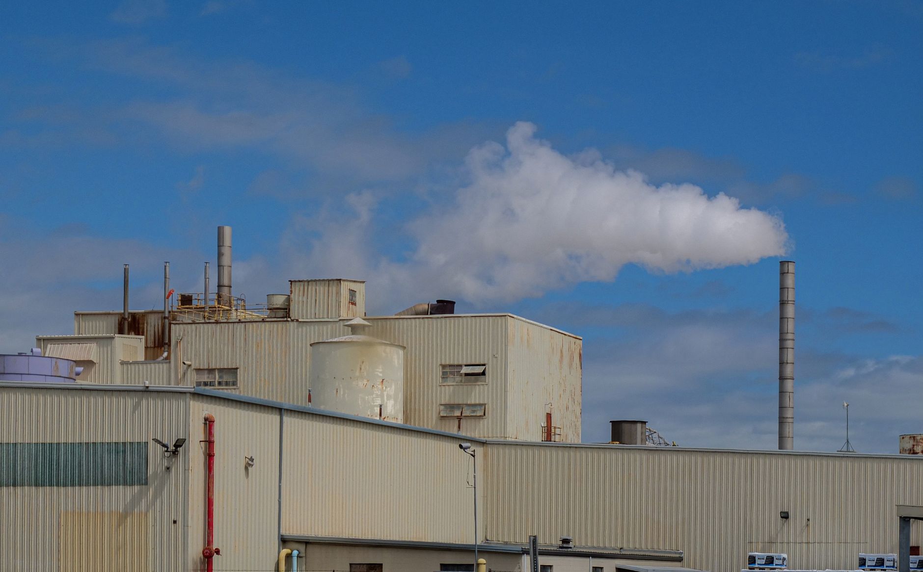 Two industrial buildings on one campus, illustrating outdoor pallet moves between production and warehouse space.