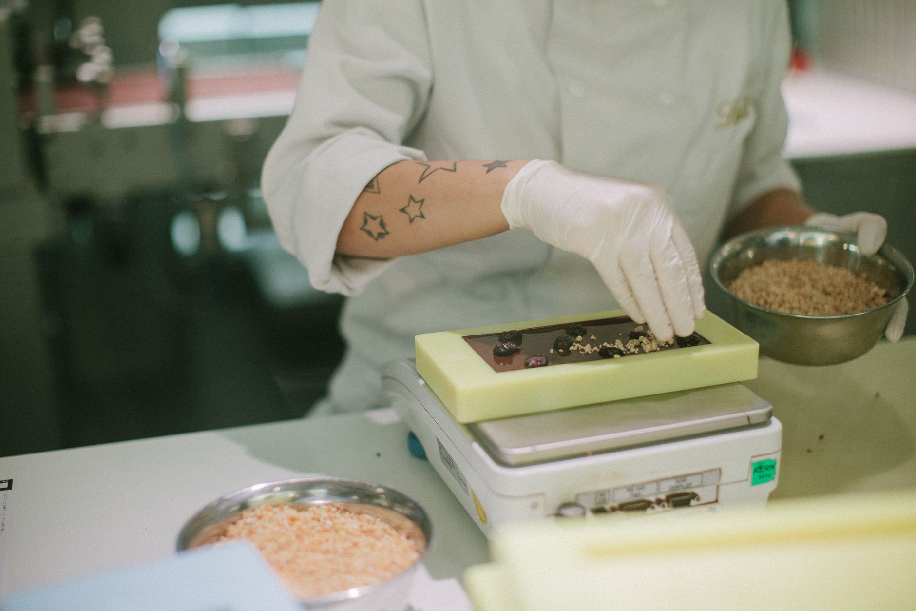 Employees work together in a confectionery production area where packaged candy moves toward end-of-line packing.
