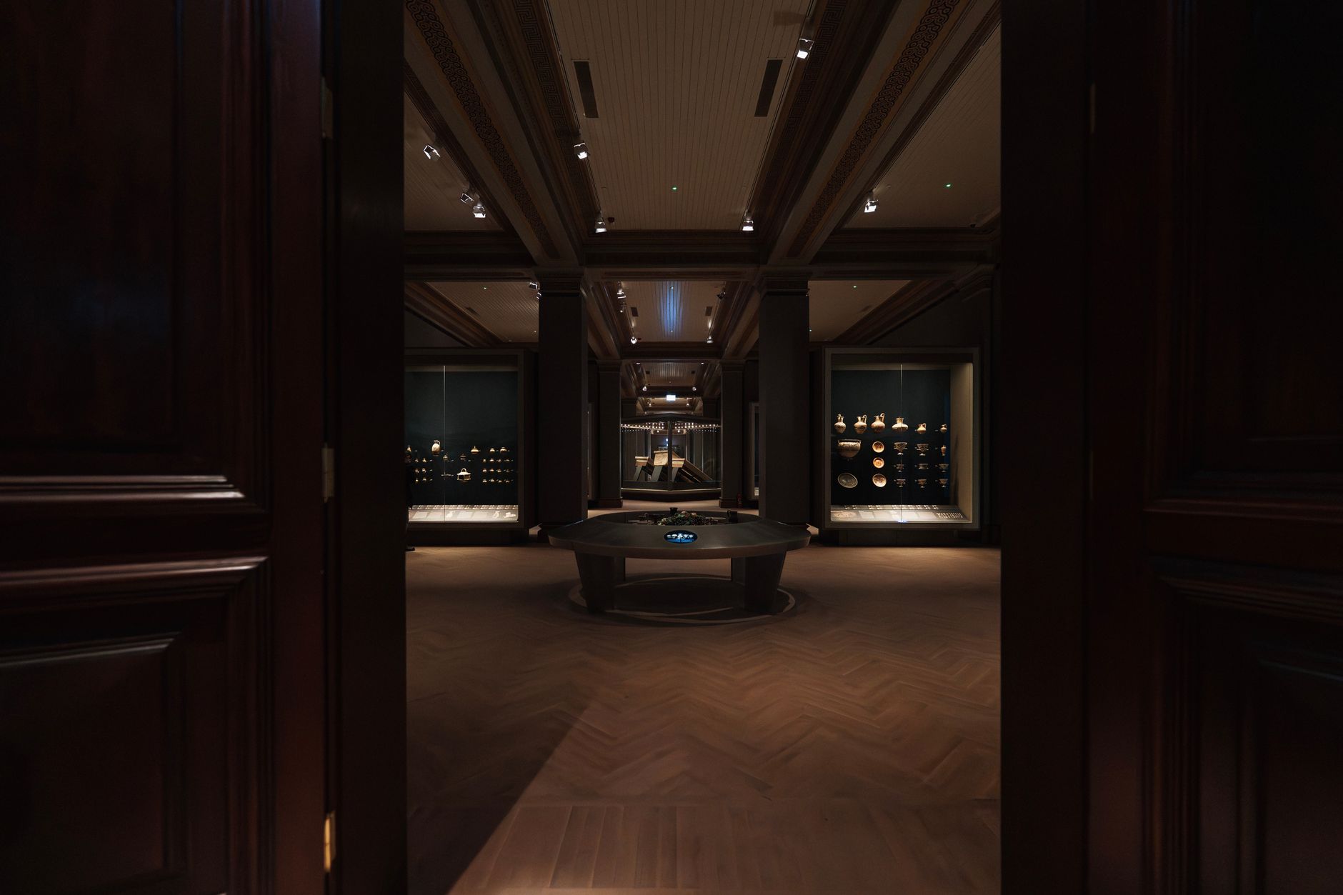 A wide museum exhibition hall shows open floor space and carefully arranged vehicle displays.