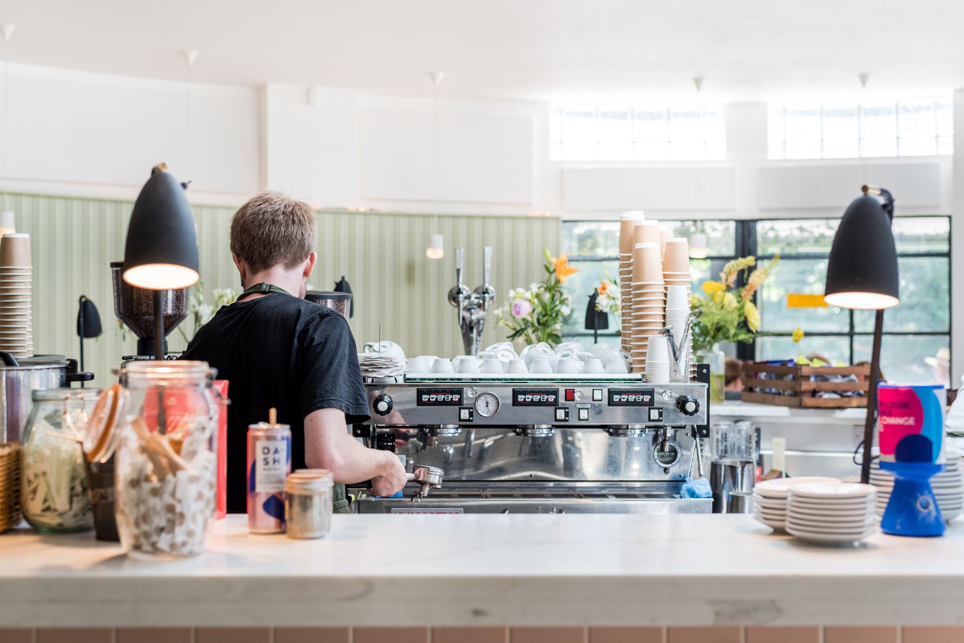 Guests lined up at the counter while staff work through a peak breakfast rush in a downtown cafe.