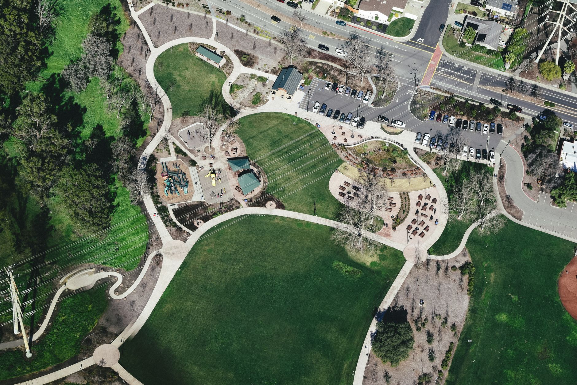 A wide view of a busy urban public park with open walkways, green space, and visitors moving through the grounds.