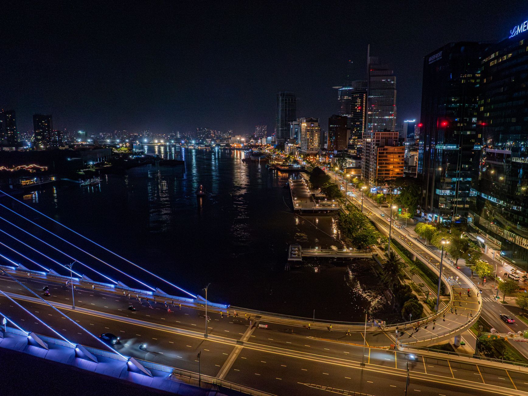 A quiet waterfront street at night illustrates the dense urban setting for low-noise municipal cleaning.