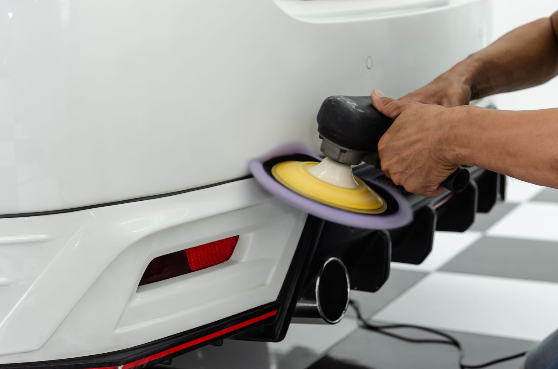 A quality technician inspects the surface finish of a painted industrial part.