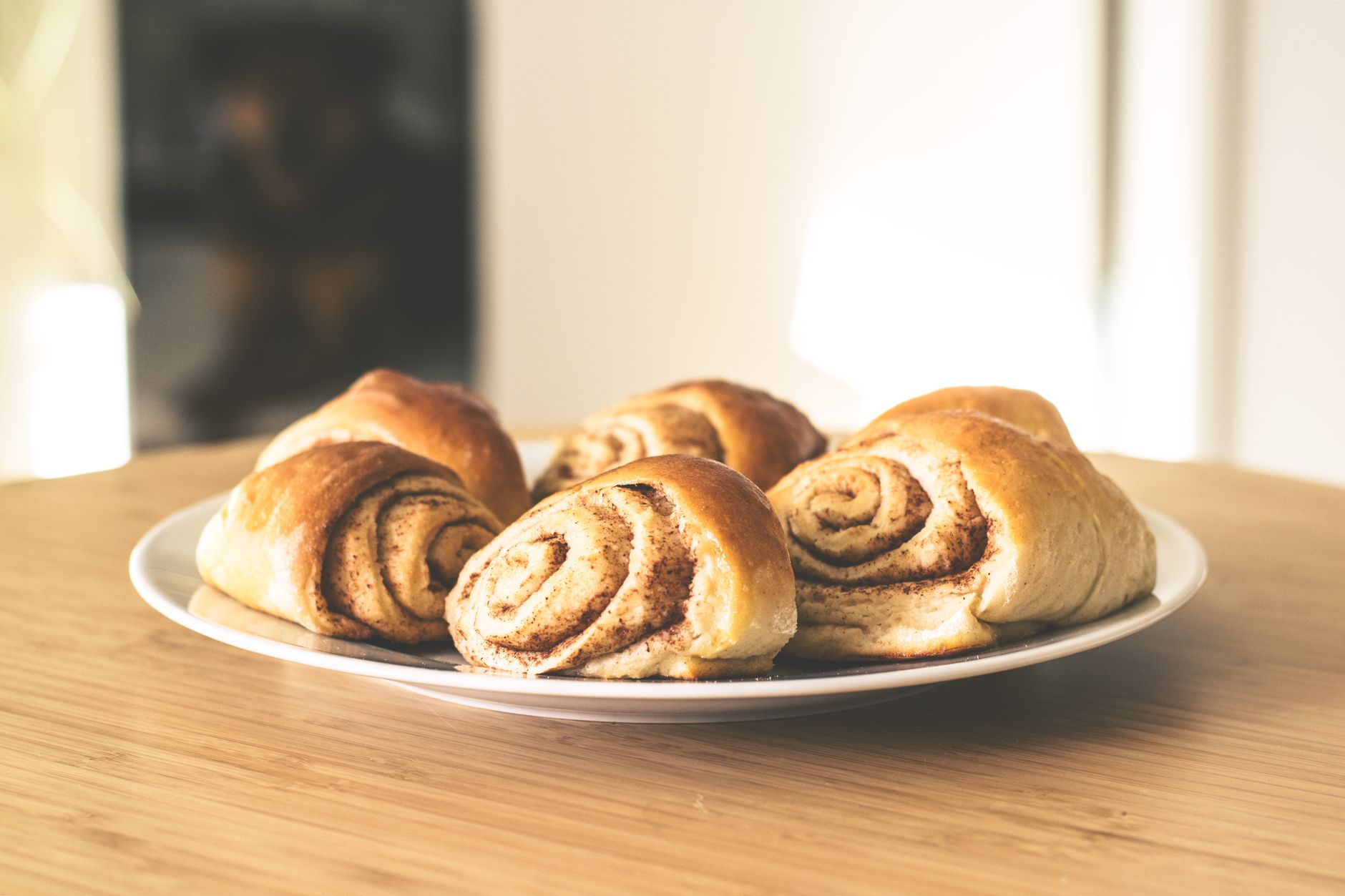 Trays of fresh cinnamon rolls cooling after baking, ready for depanning.