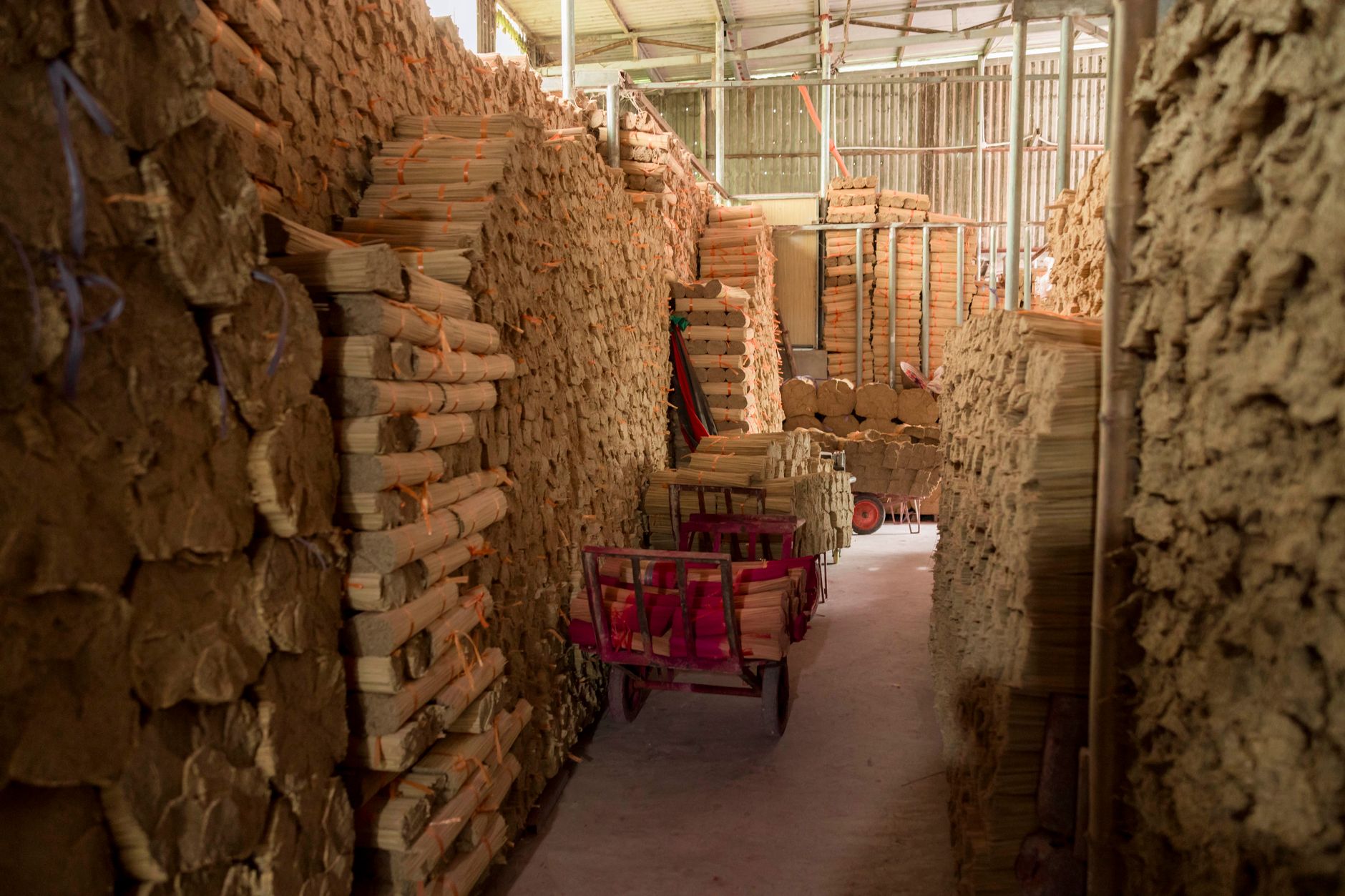 Stacked paper and cartons in a warehouse aisle, echoing seasonal skid clutter on a reshaping print floor.