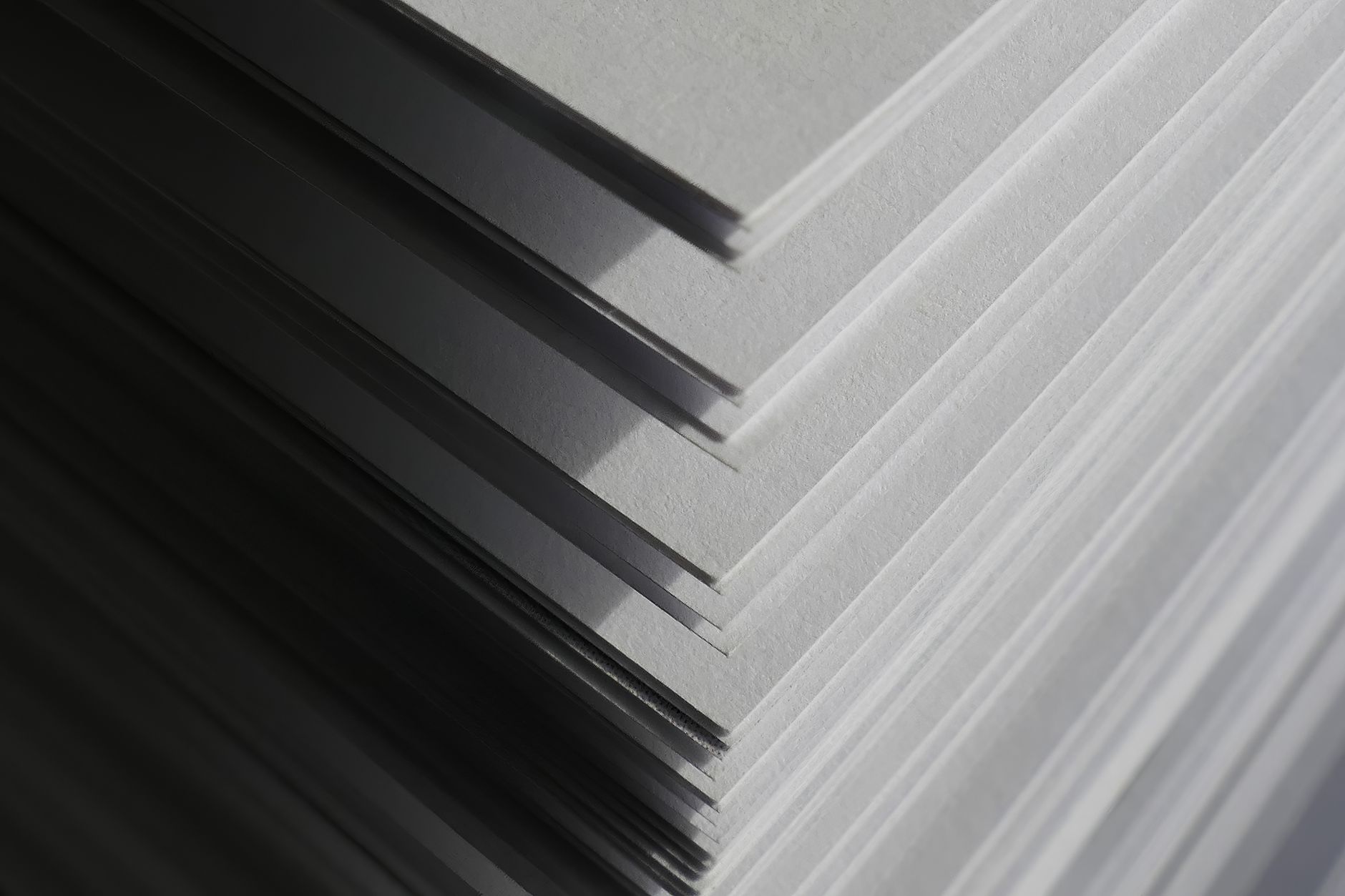 Stacked printing plates or press materials beside a production station, illustrating the repetitive handoff that was automated in the case study.