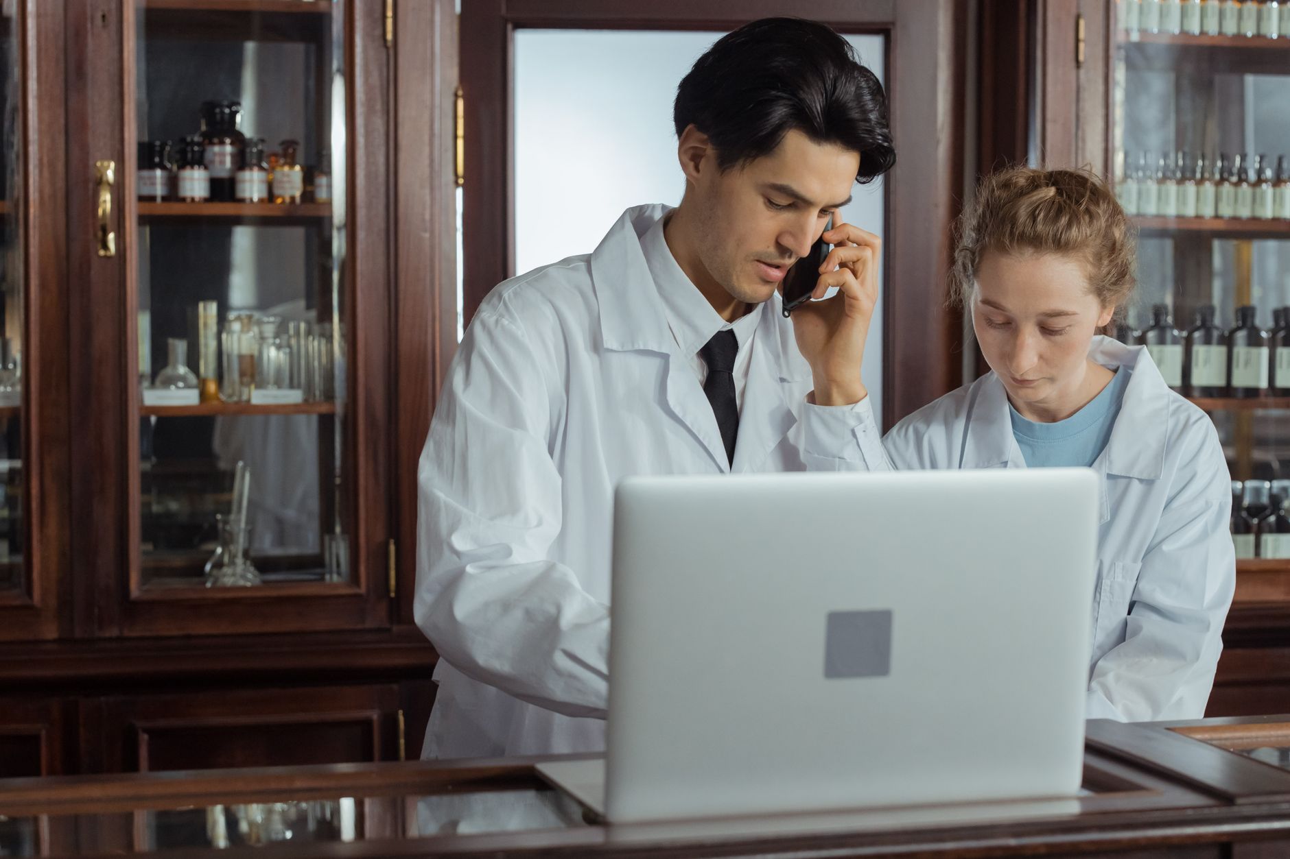 A community pharmacist advising a patient at the pharmacy counter.