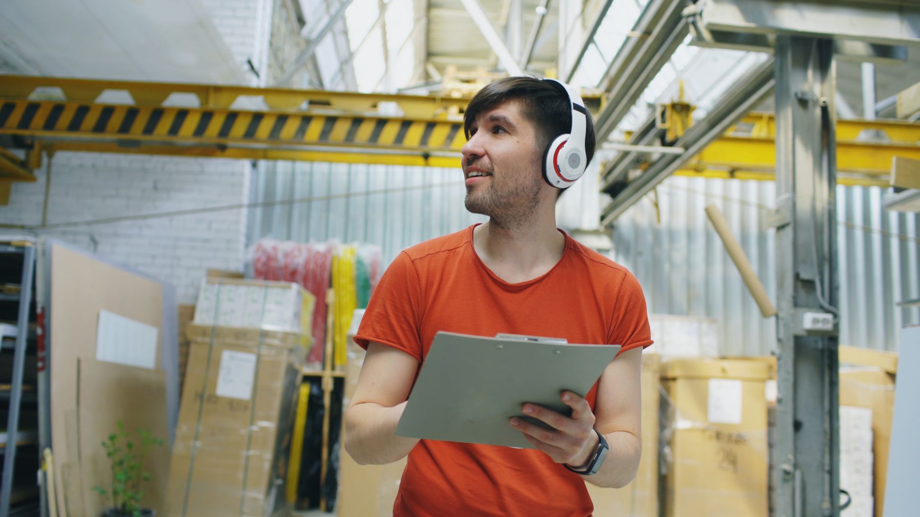 A warehouse associate reviews paperwork near stocked shelves during a rollout planning walkthrough.