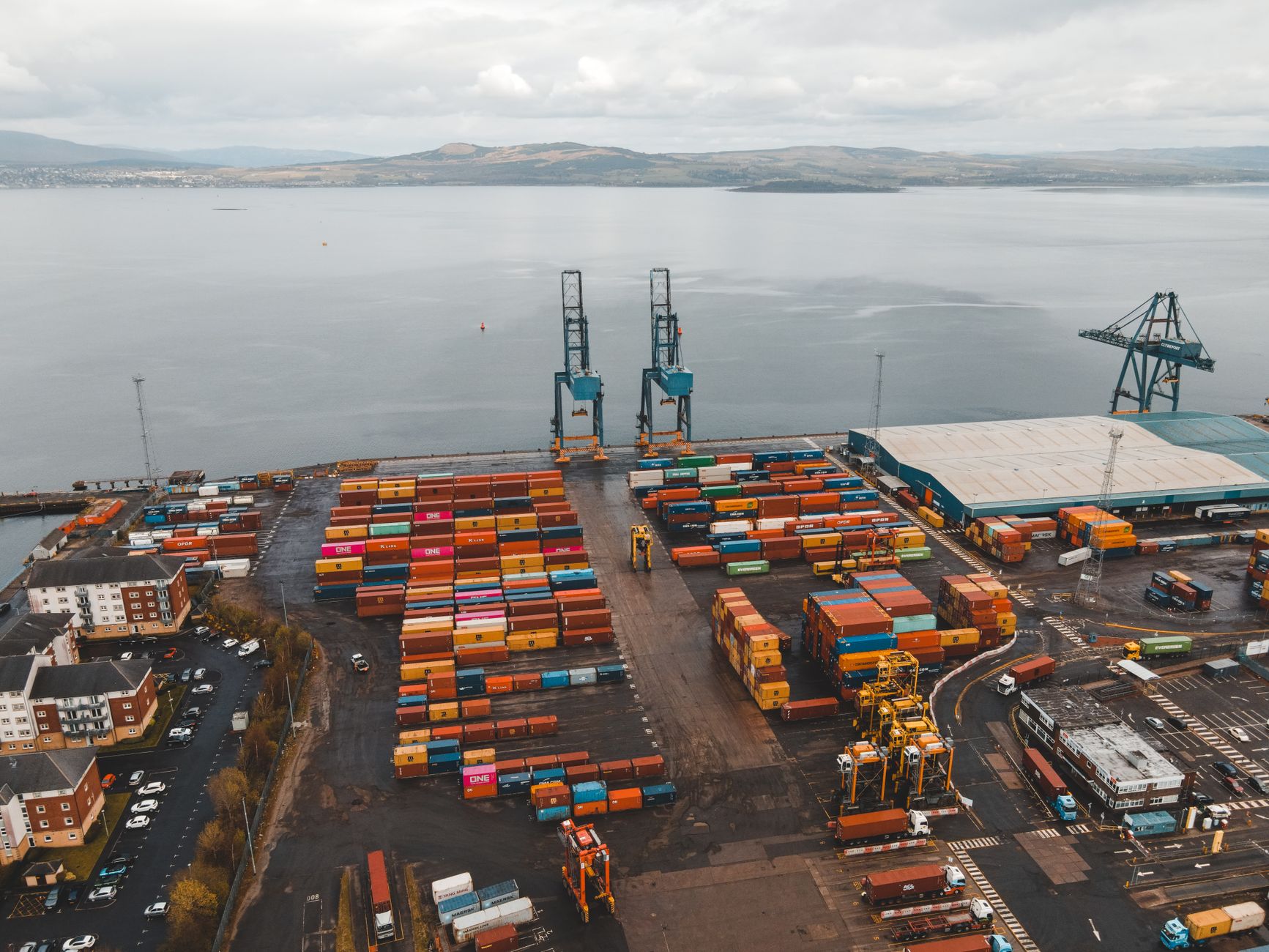 An aerial view of a busy container terminal with a cargo ship secured alongside the quay.