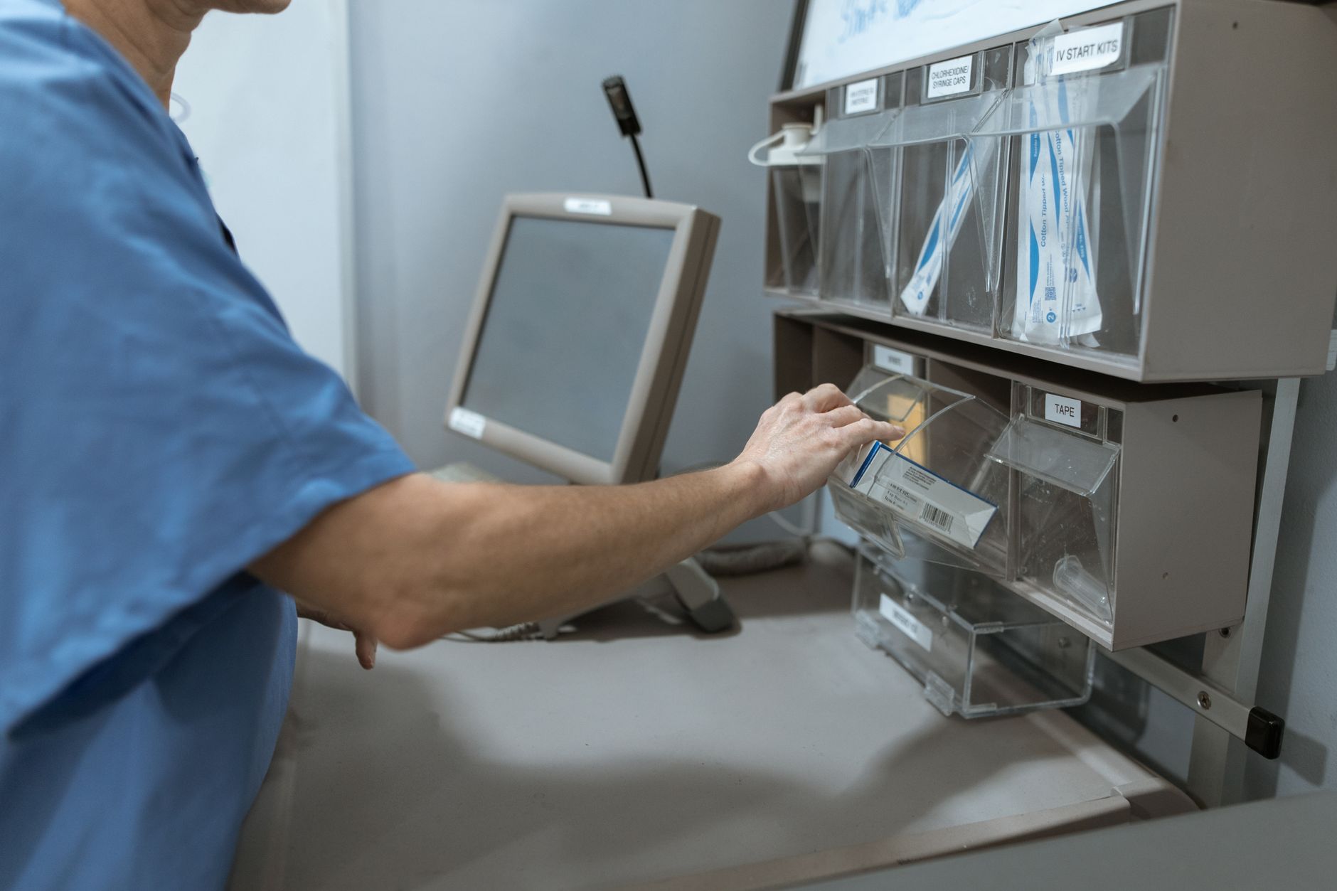 A nurse moving a supply cart through a clinical corridor, reflecting repetitive internal transport work shifted away from bedside staff.