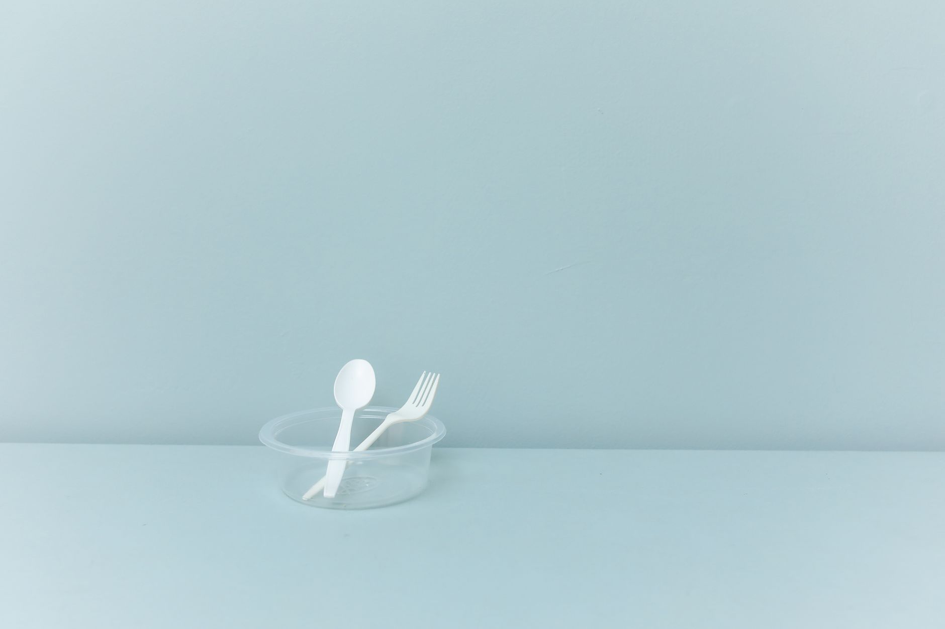 Loose plastic forks and spoons, the pieces an operator loads into hoppers before wrapping.