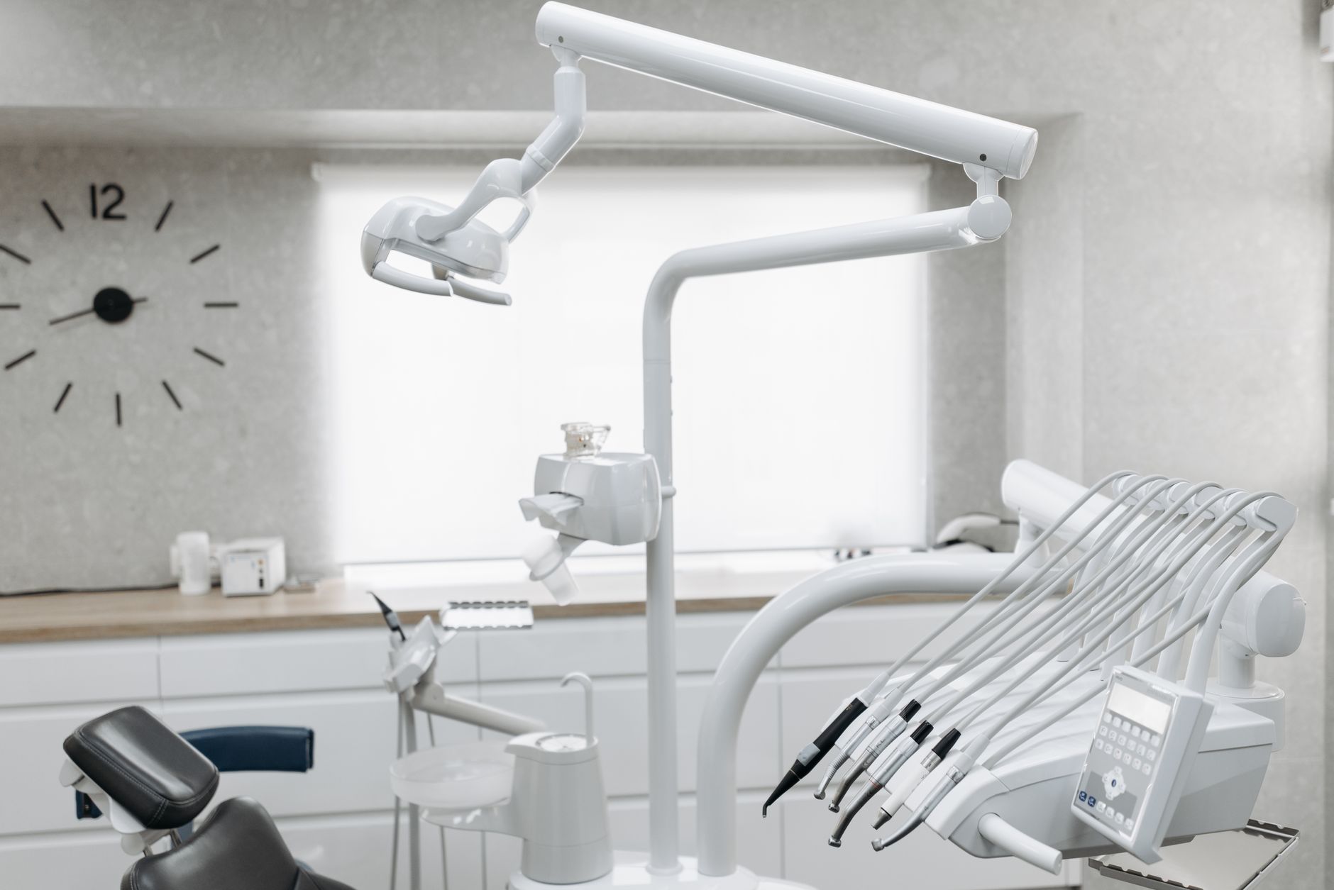 A bright, modern dental treatment room with a clear walkway between clinical work areas.