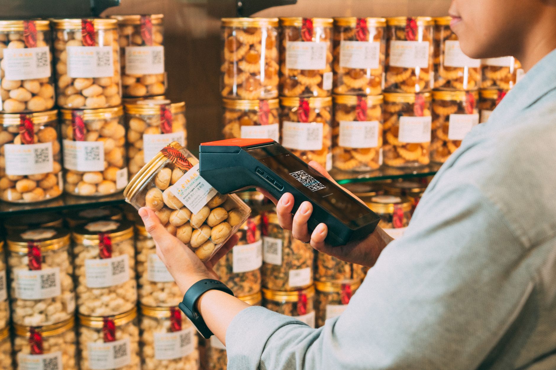 A fulfillment associate scanning a product barcode while picking inventory from warehouse shelving.