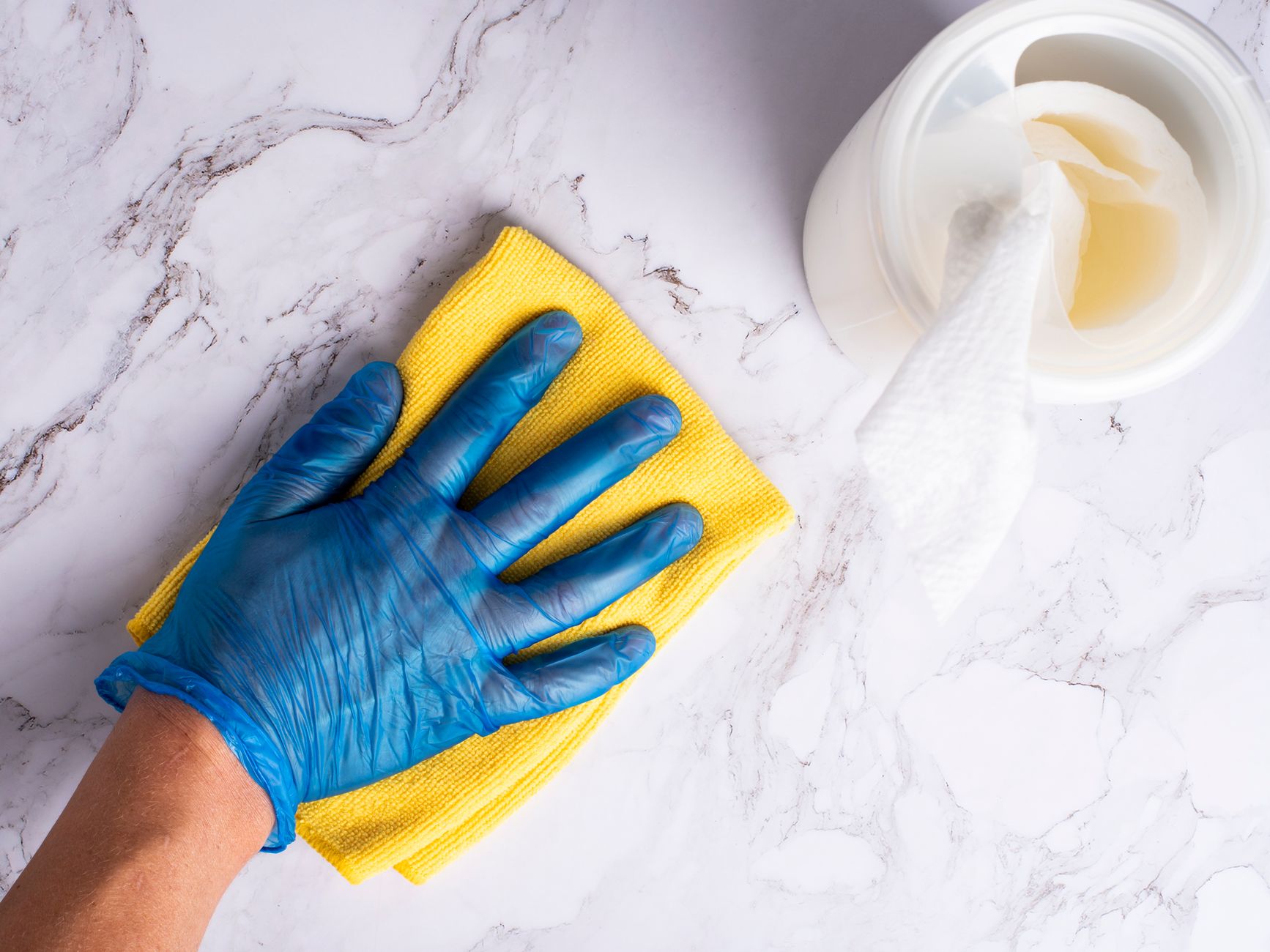 Housekeeping staff cleaning a communal kitchen counter and appliances.