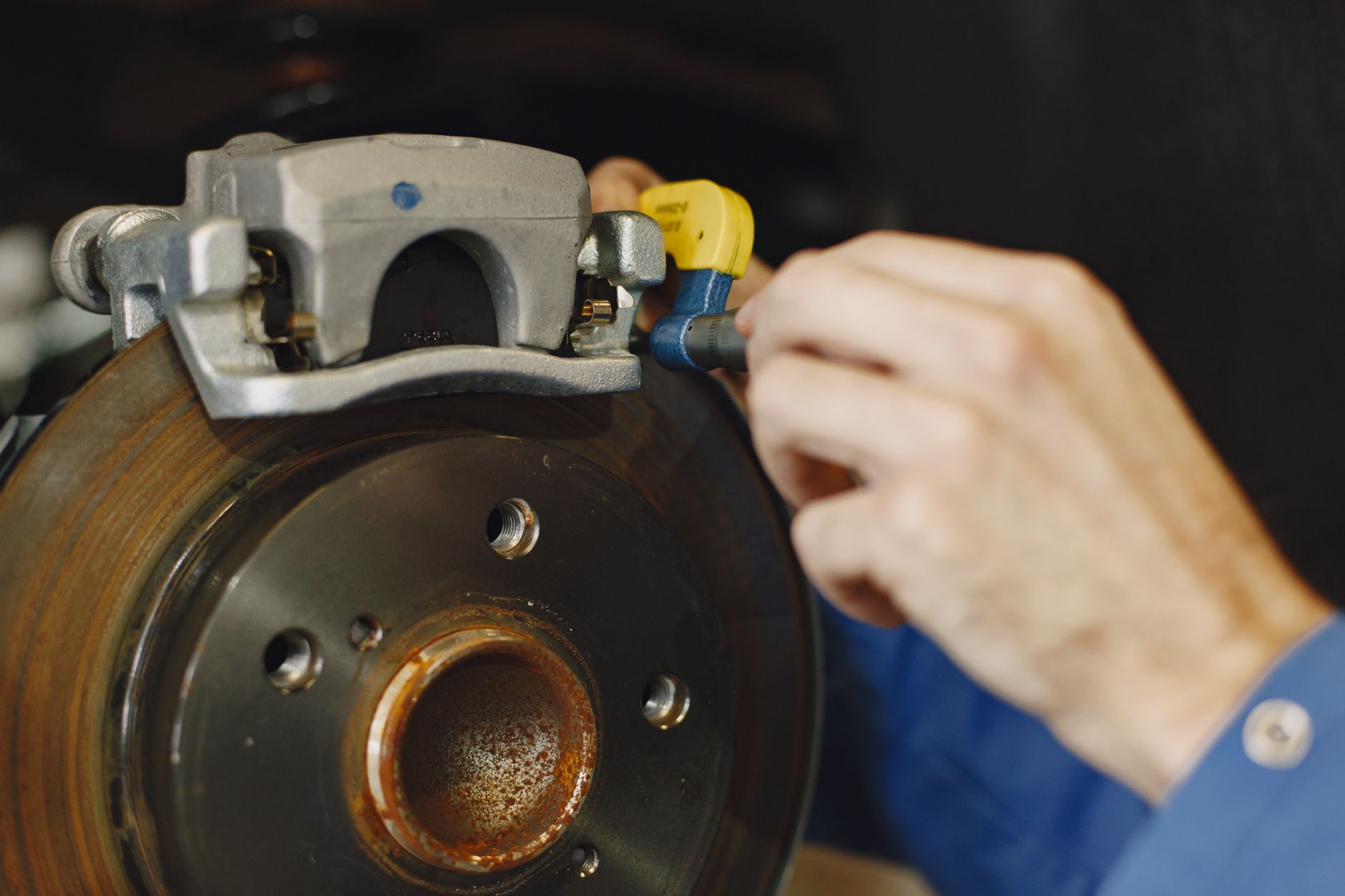 A technician uses a caliper to inspect the dimensions of small precision metal components.