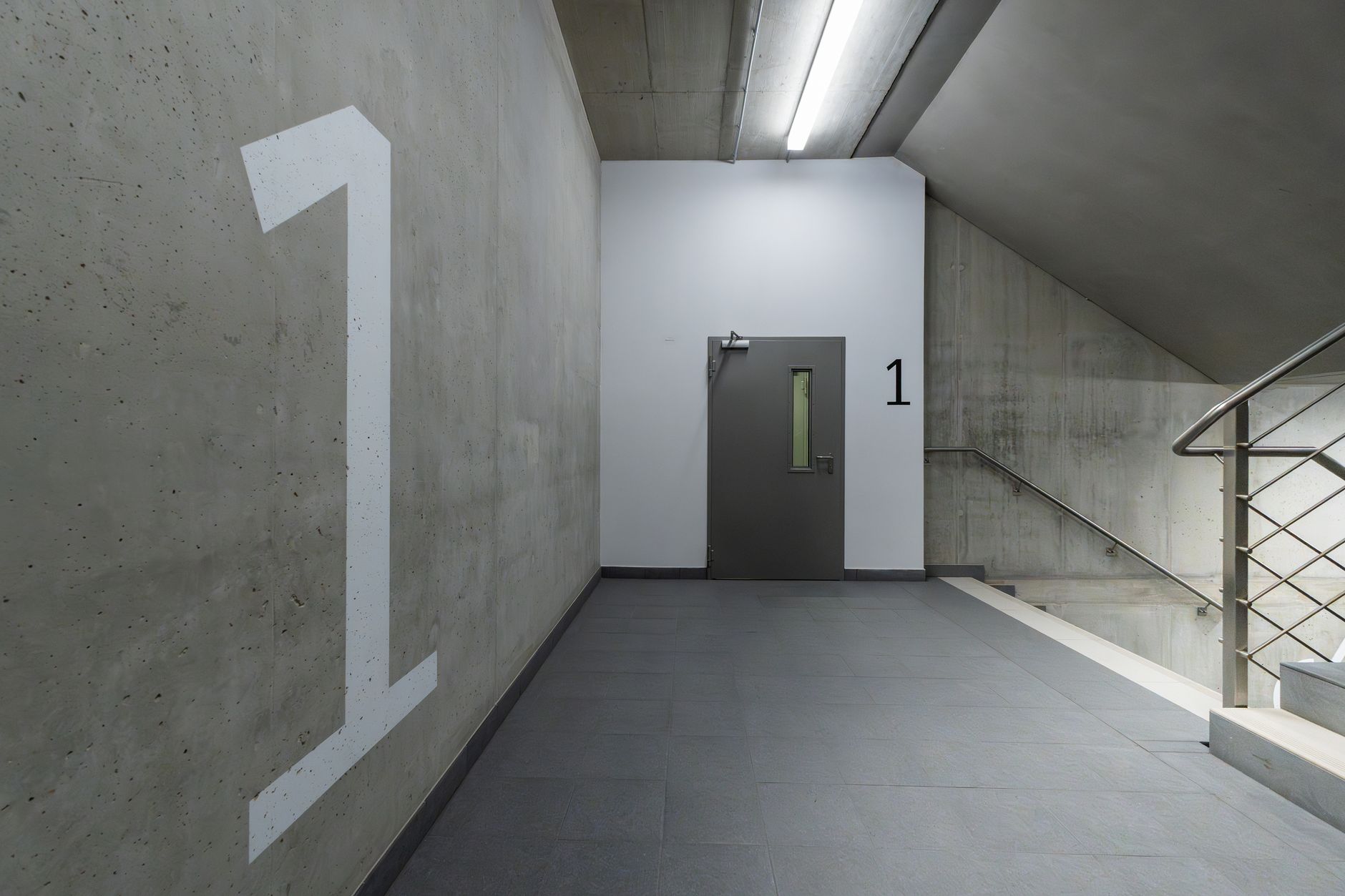 Concrete stairwell inside a parking structure, representing the blind spots and stacked levels where incidents often happen out of immediate staff view.