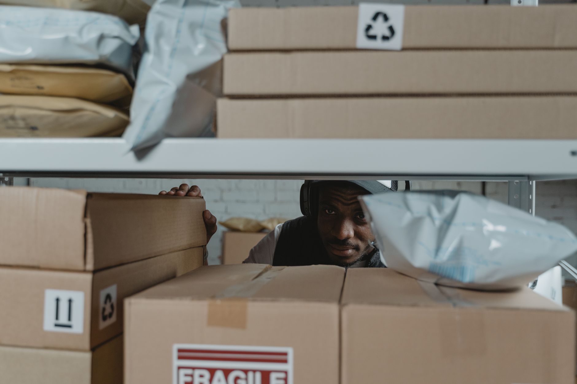 An operator remains focused on packing and sealing a parcel at the workstation.