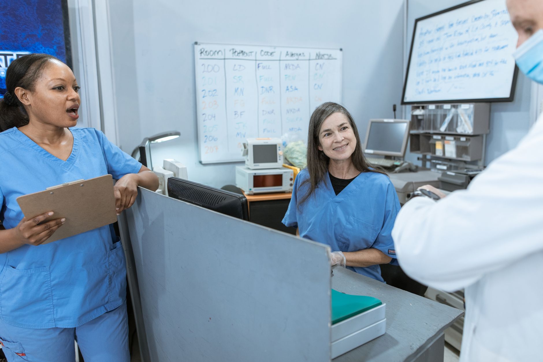 Clinicians at a nurses station, representing the bedside minutes regained when couriers handled the 1.6 mile driving loop.