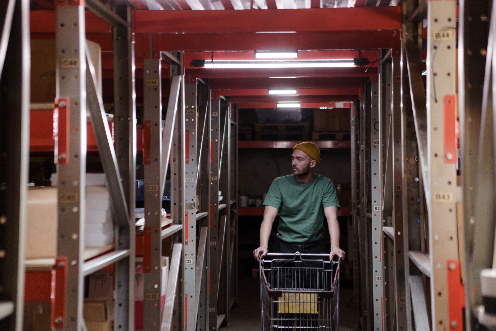 Rolling carts in a warehouse aisle, representing the repetitive material transfers this manufacturer automated between storage and assembly.