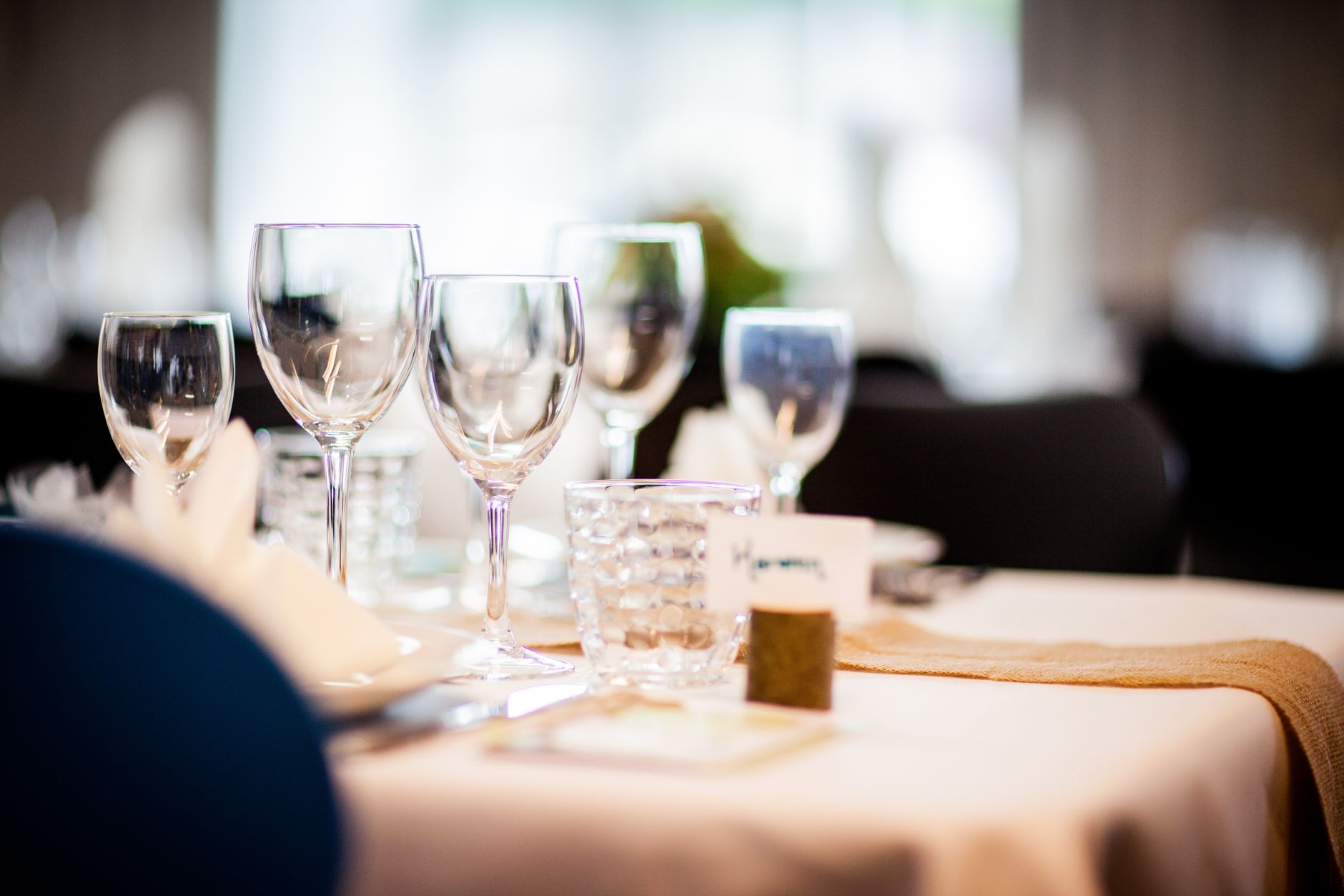 A worker quickly clearing and resetting a large restaurant table between seatings.