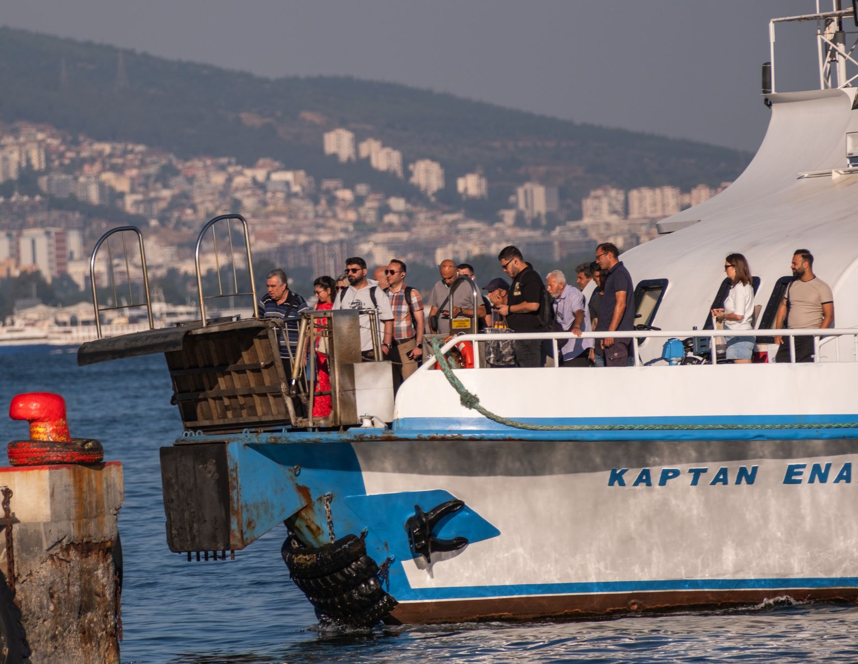 A passenger ferry travels through a busy harbor on a scheduled route.