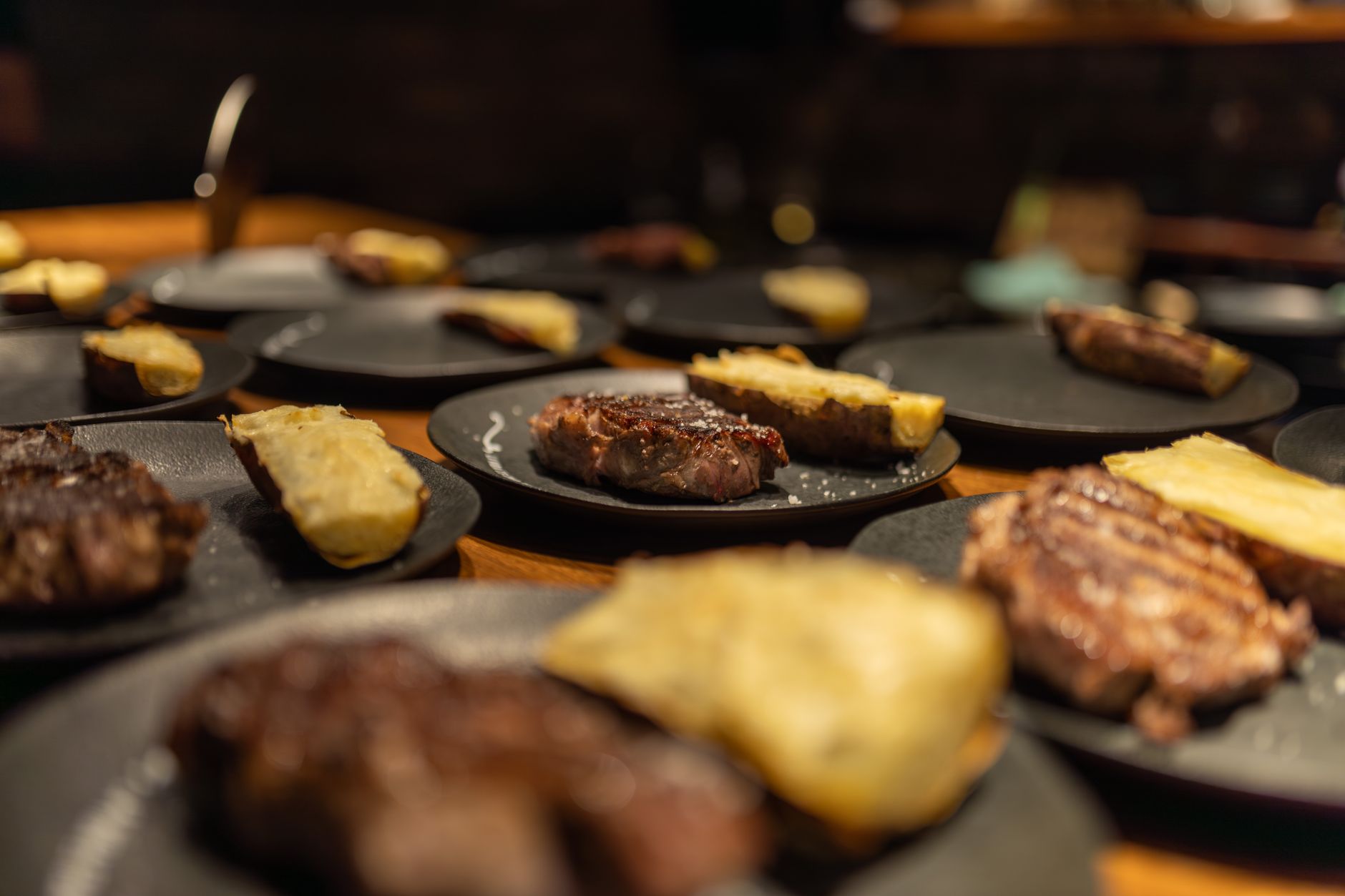 An elegant steakhouse dining room is prepared for attentive table-side service.