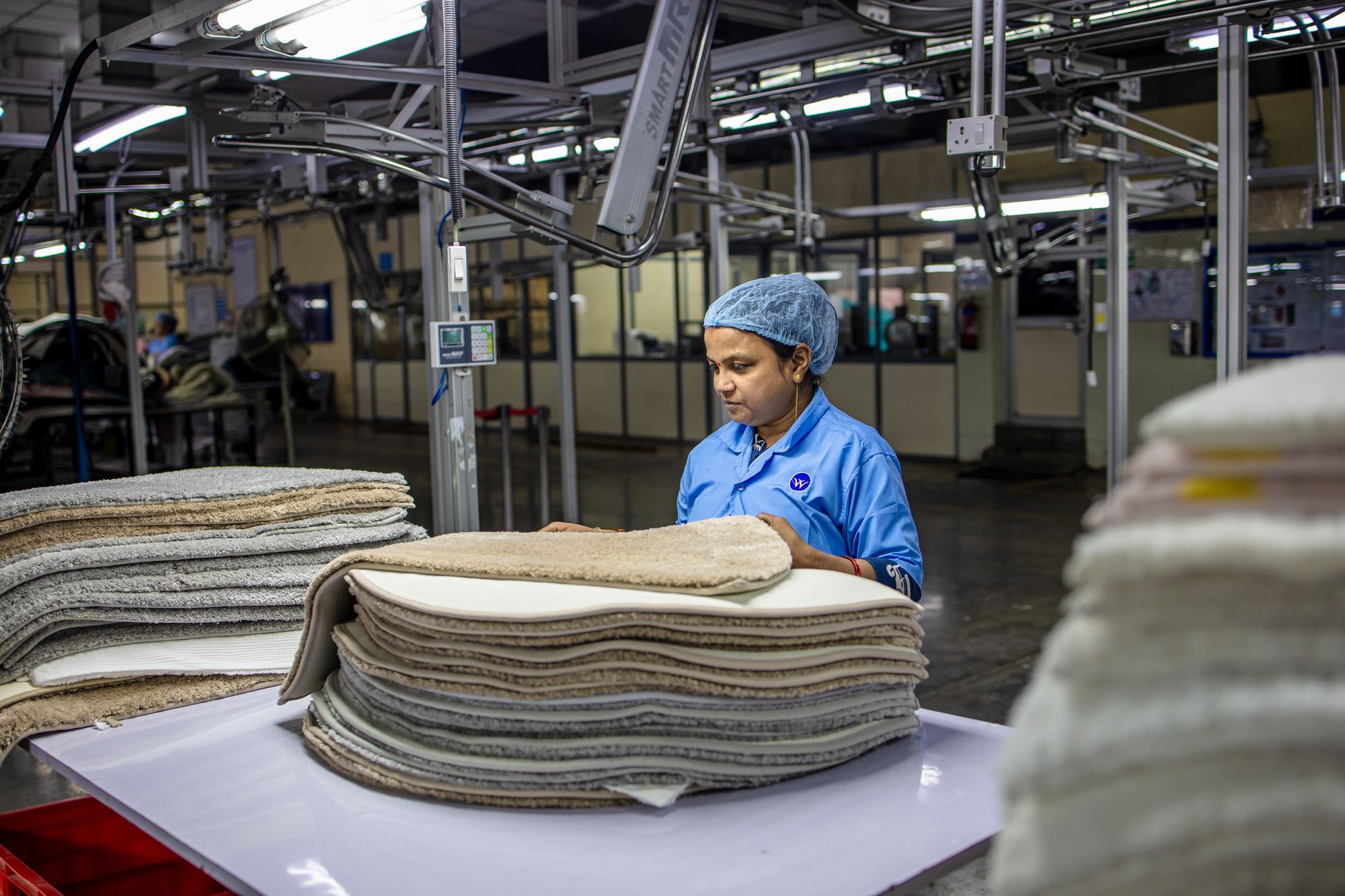 A plant supervisor on the production floor reviewing throughput after palletizing labor was redeployed.