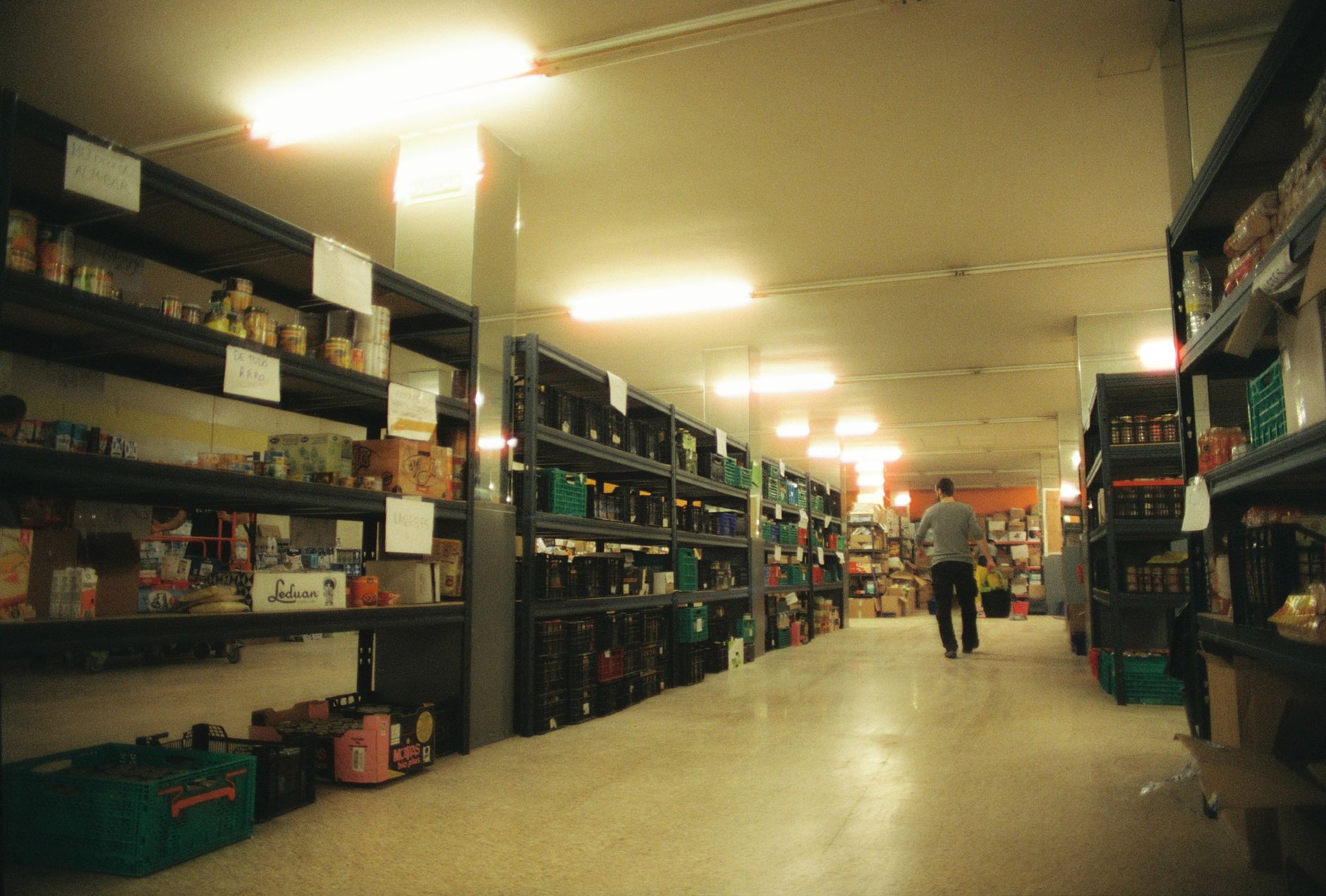A grocery warehouse aisle where pickers fulfill fresh orders with less walking when AMRs guide routes.