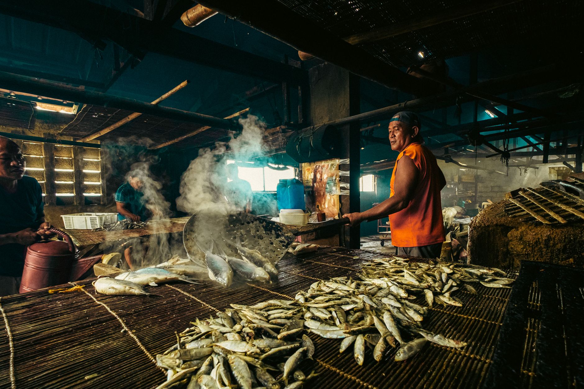 Seafood processing employees work together on a commercial packing floor.