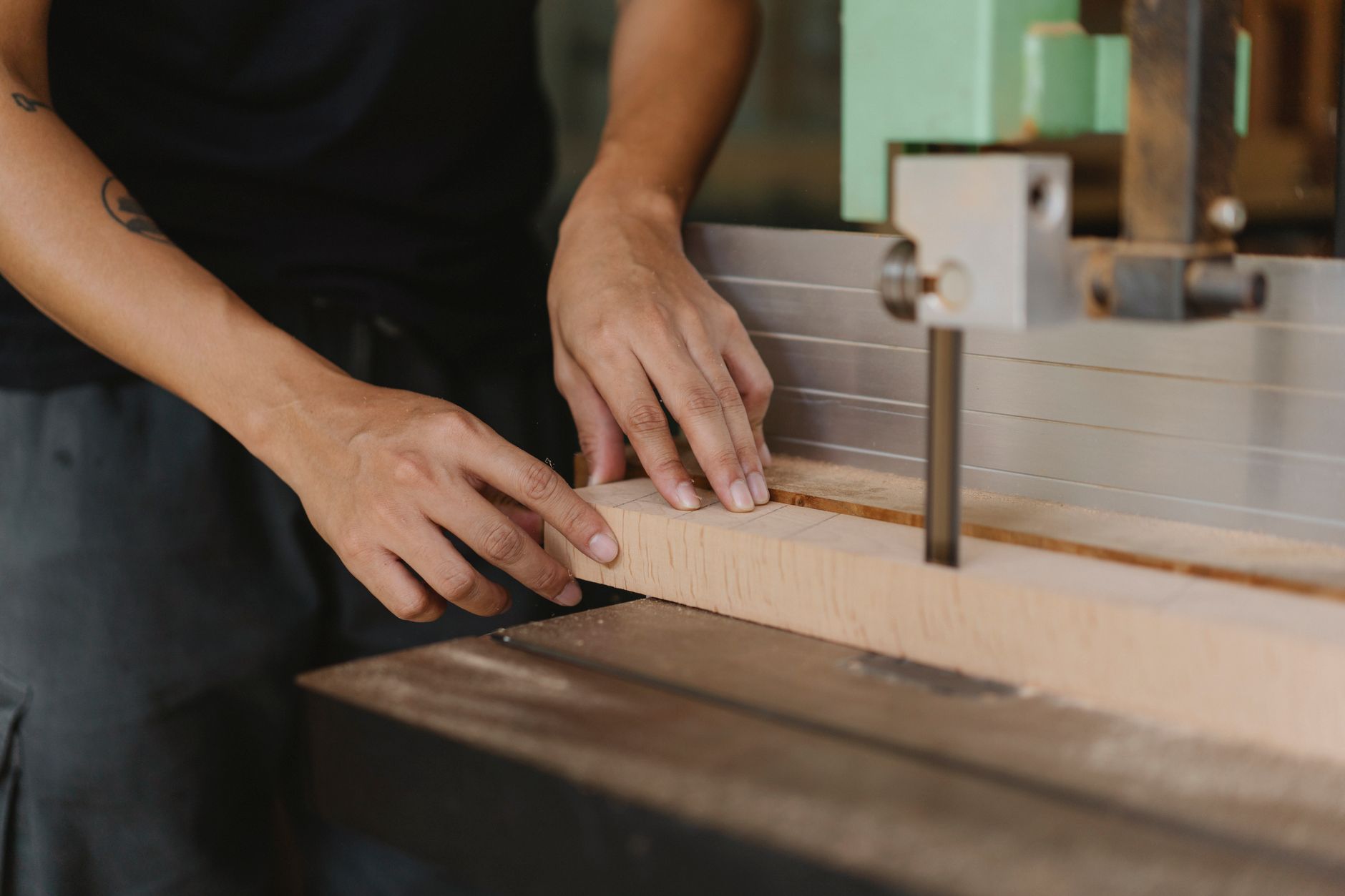 Panels moving through woodworking machinery before robotic stacking at the outfeed.