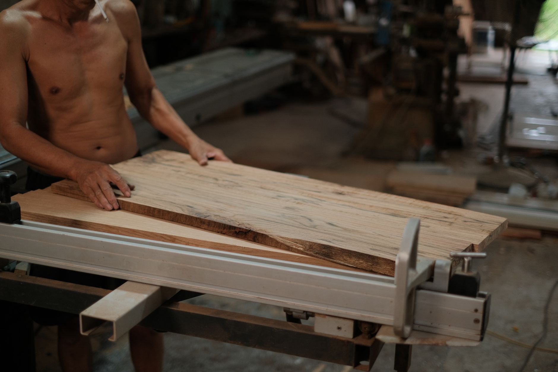 Stacked wood panels in a custom furniture shop where edge banding and palletizing share one line.